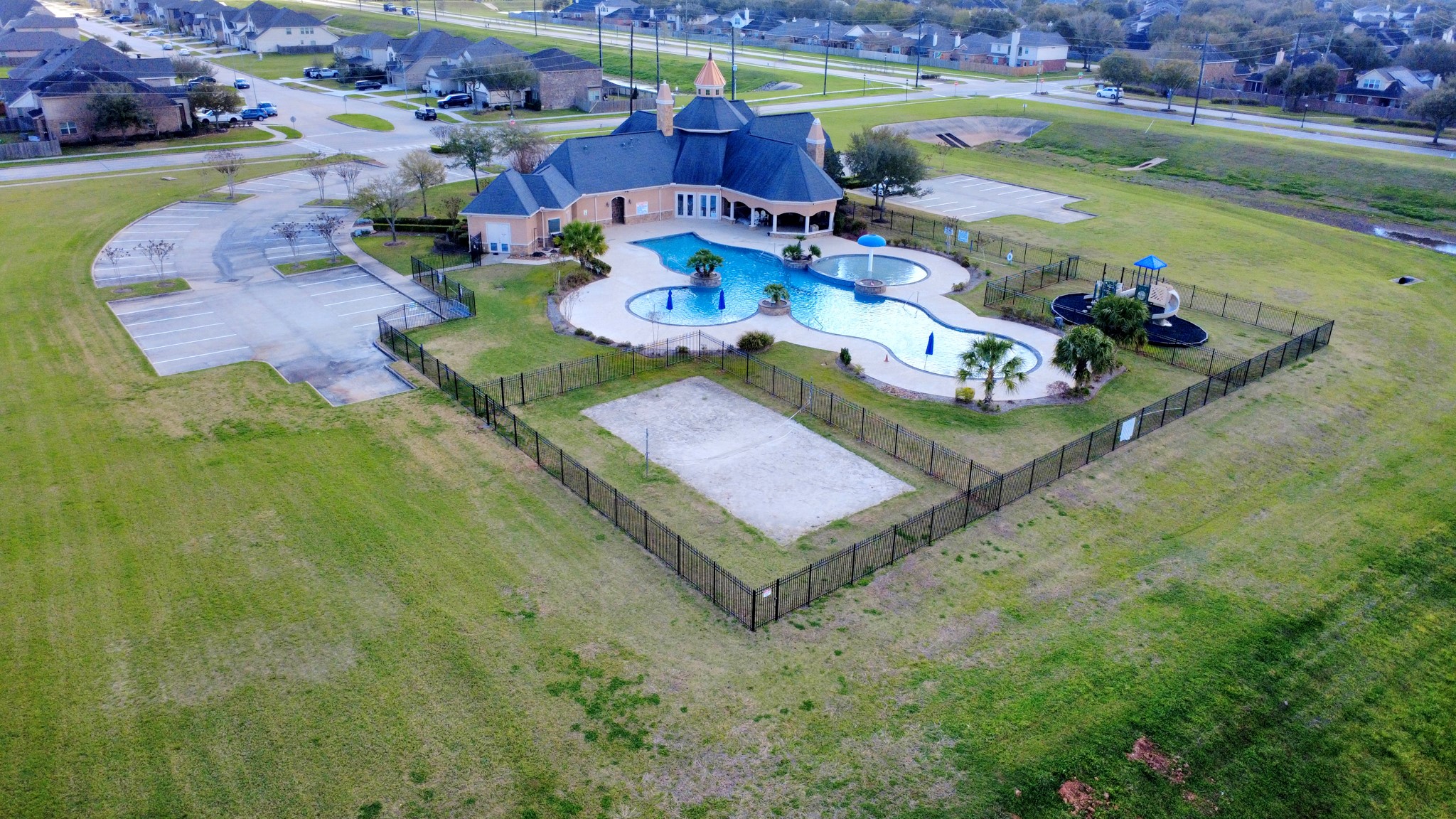 Community clubhouse, pool, volleyball area, and playground amenities