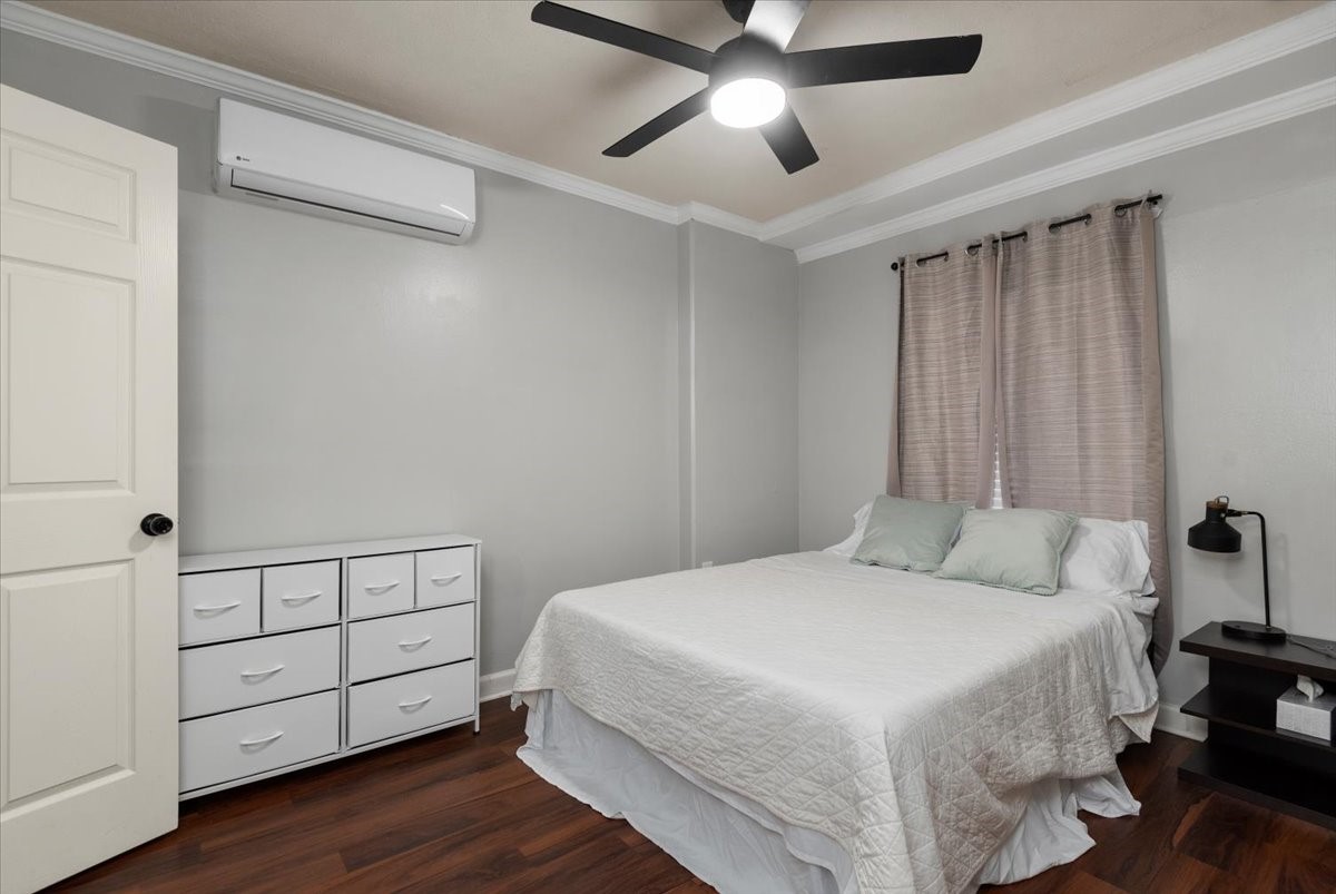 Spacious bedroom with ceiling fan and natural light.