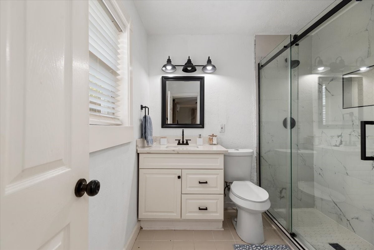 Downstairs unit bathroom with updated vanity and walk-in shower.