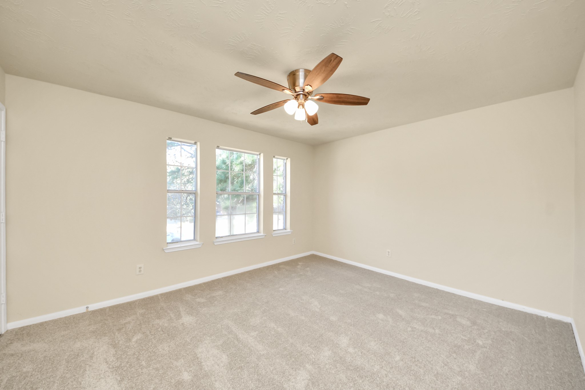 Another secondary bedroom with ceiling fan and large window.