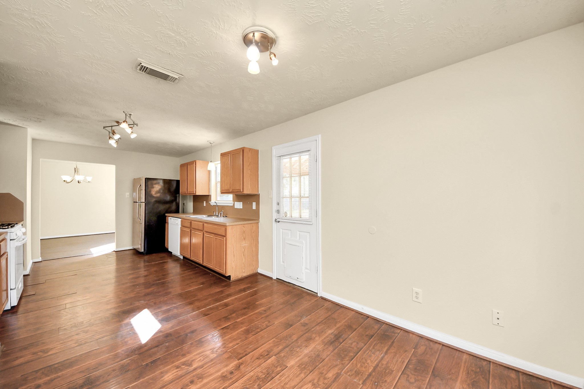 View from breakfast nook, looking into kitchen. Door leads to backyard. Access to garage off nook. Plenty of natural light!