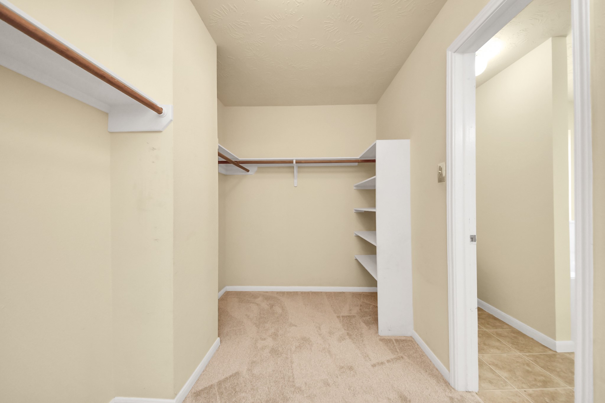 Another view of the walk-in closet with ample shelving and hanging space.