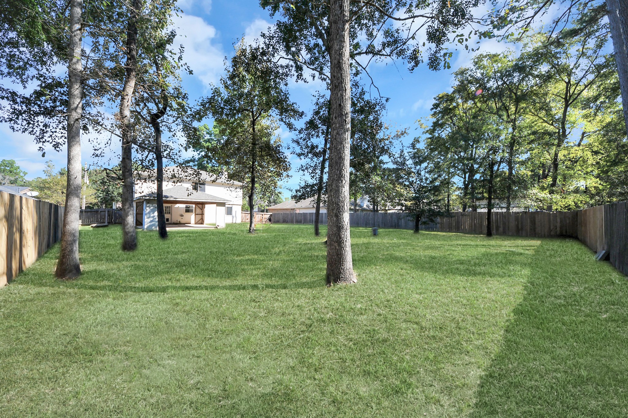 Mature trees cover this large backyard, offering a serene private retreat. Photo: AI assisted for grass growth.