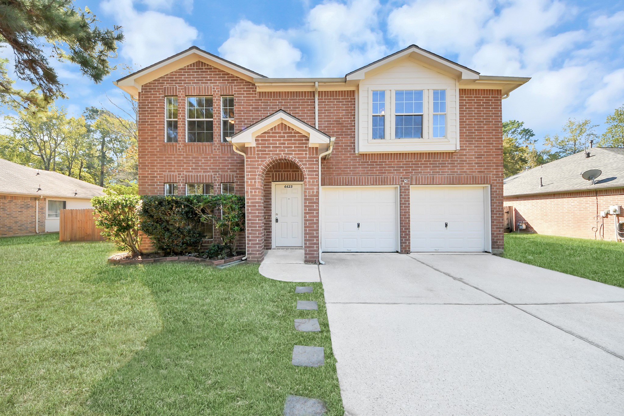 Spacious two-story brick home with arched entryway, two-car garage, extended driveway and large lot.
