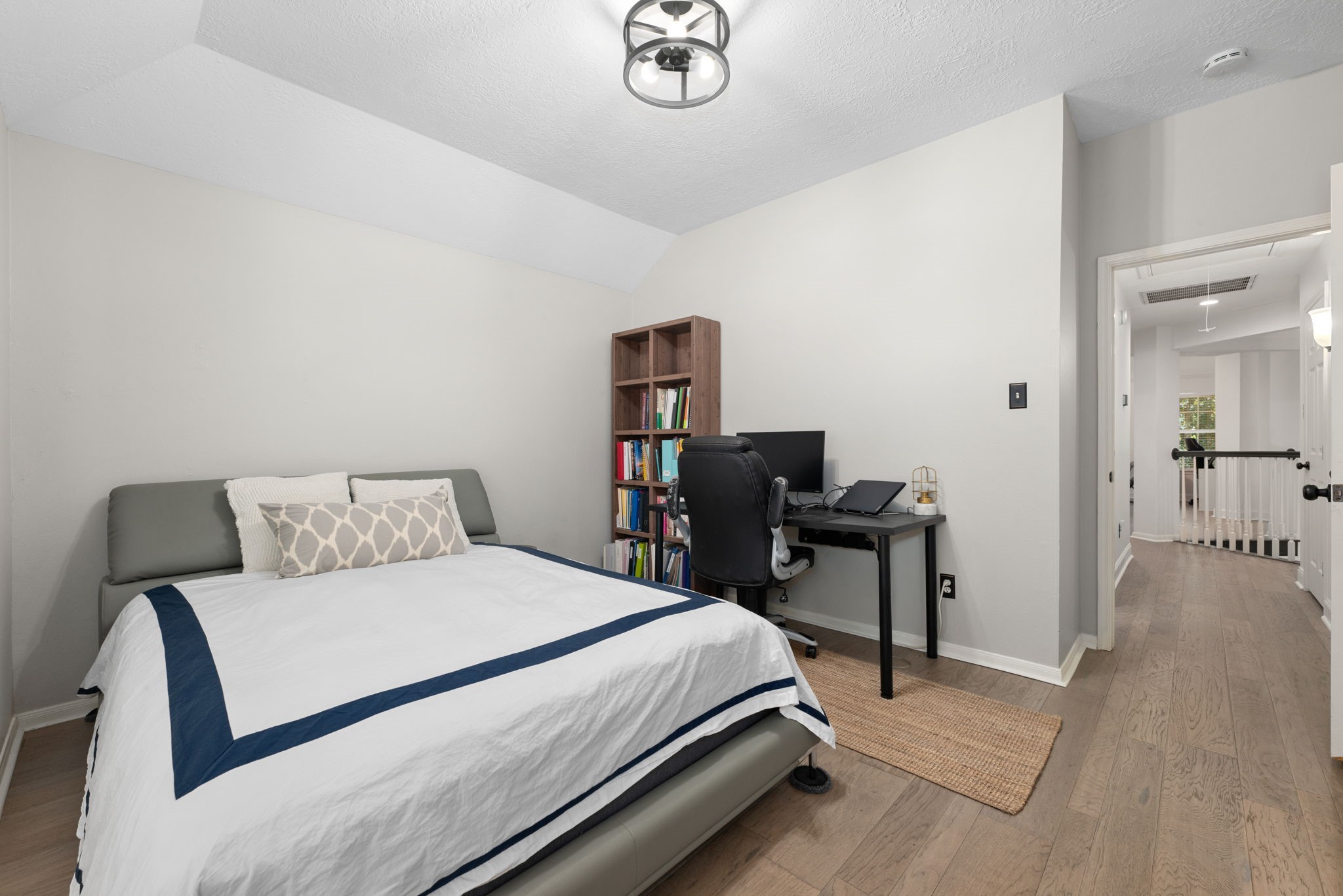 Bright and inviting secondary bedroom with a spacious bay window, elegant wood flooring.
