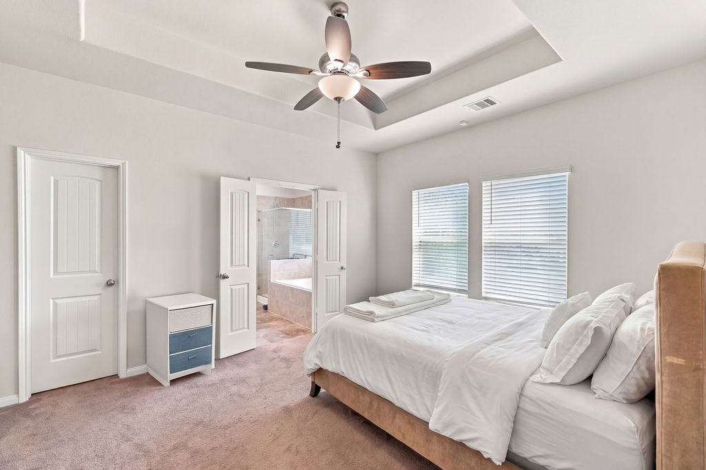 Virtually staged primary bedroom and bathroom with large closet space.
