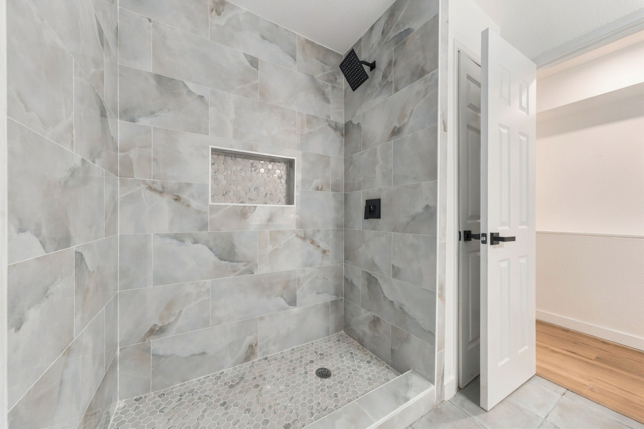 Gorgeous tiled shower with rainfall shower head and modern finishes.