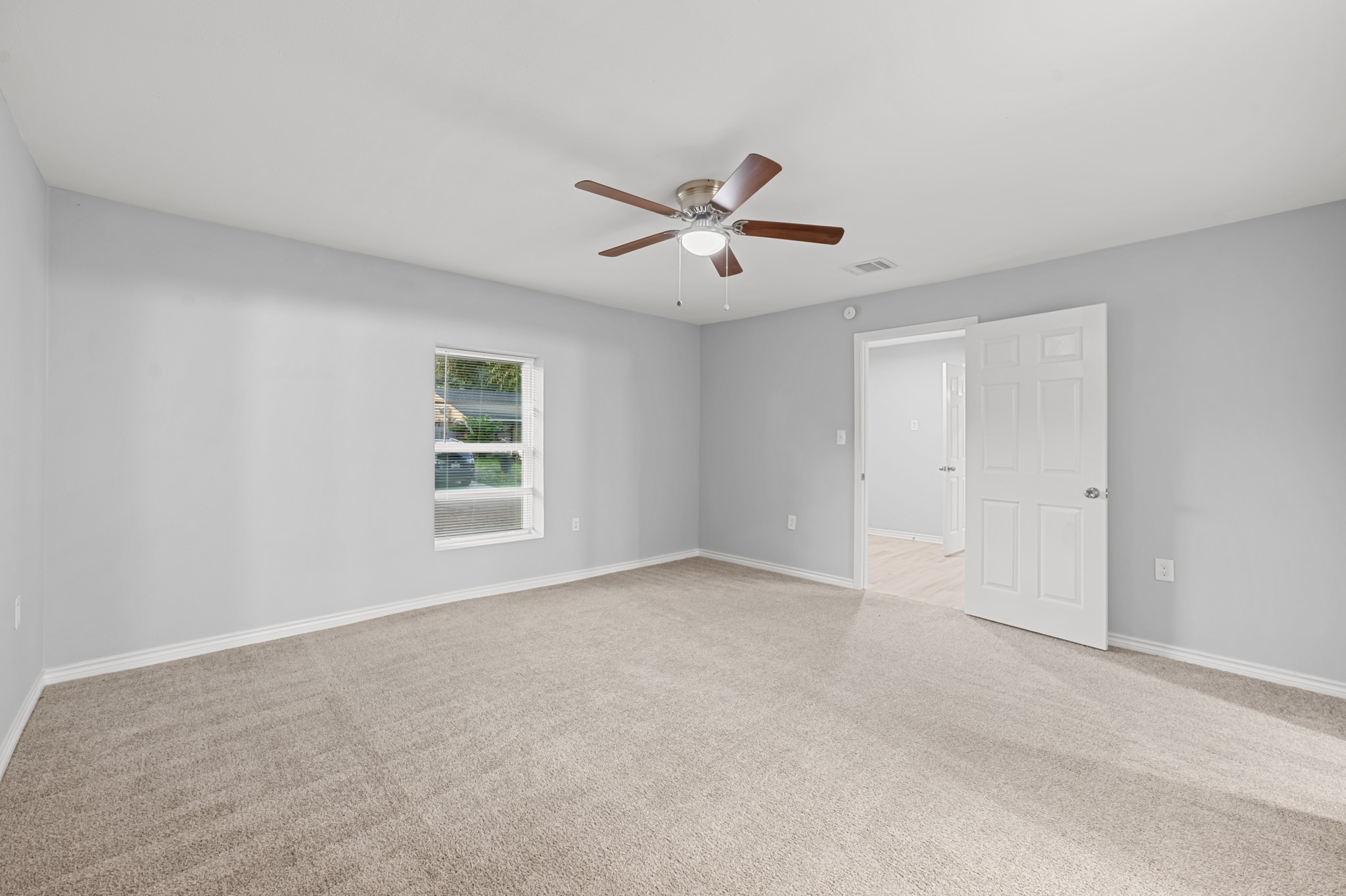 Another perspective highlights the primary bedroom's generous dimensions, providing plenty of flexibility for bedroom furniture and creating a comfortable personal retreat.