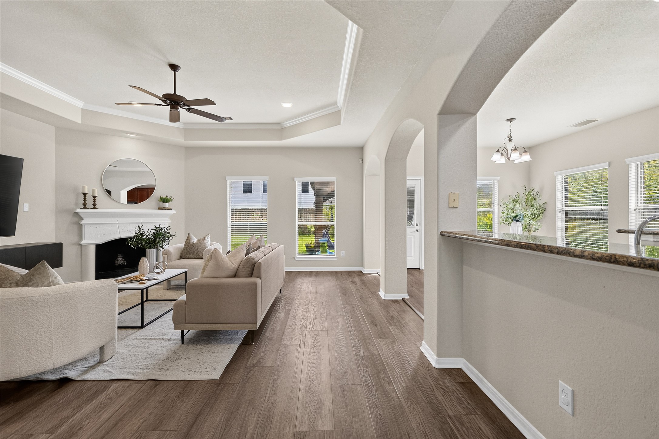 Your open-concept family room brings everyone together with a cozy fireplace, tray ceiling, and seamless flow into the kitchen and breakfast area.