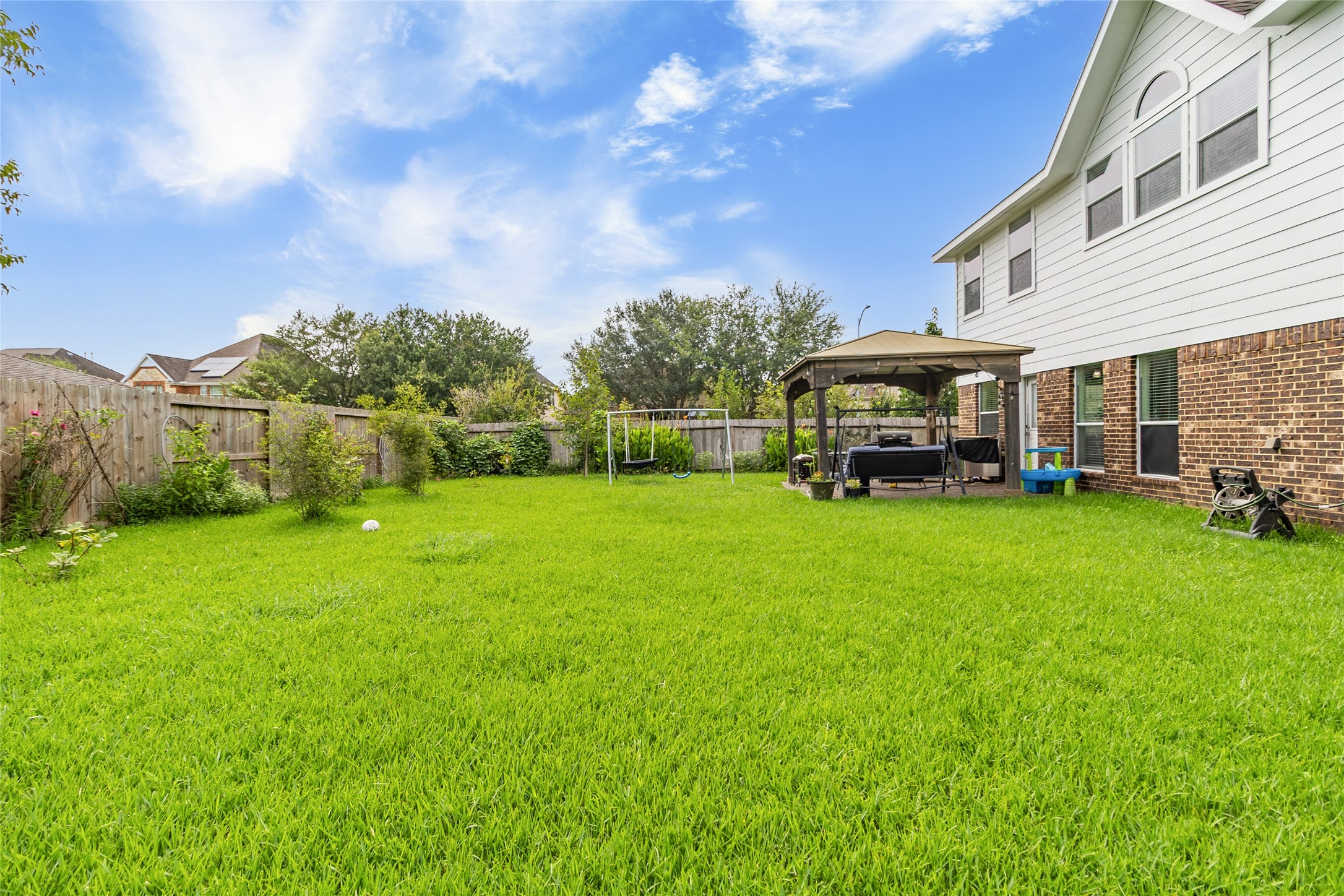 Weekend gatherings are easy with a spacious backyard, covered gazebo, and plenty of open green space for everyone to enjoy.