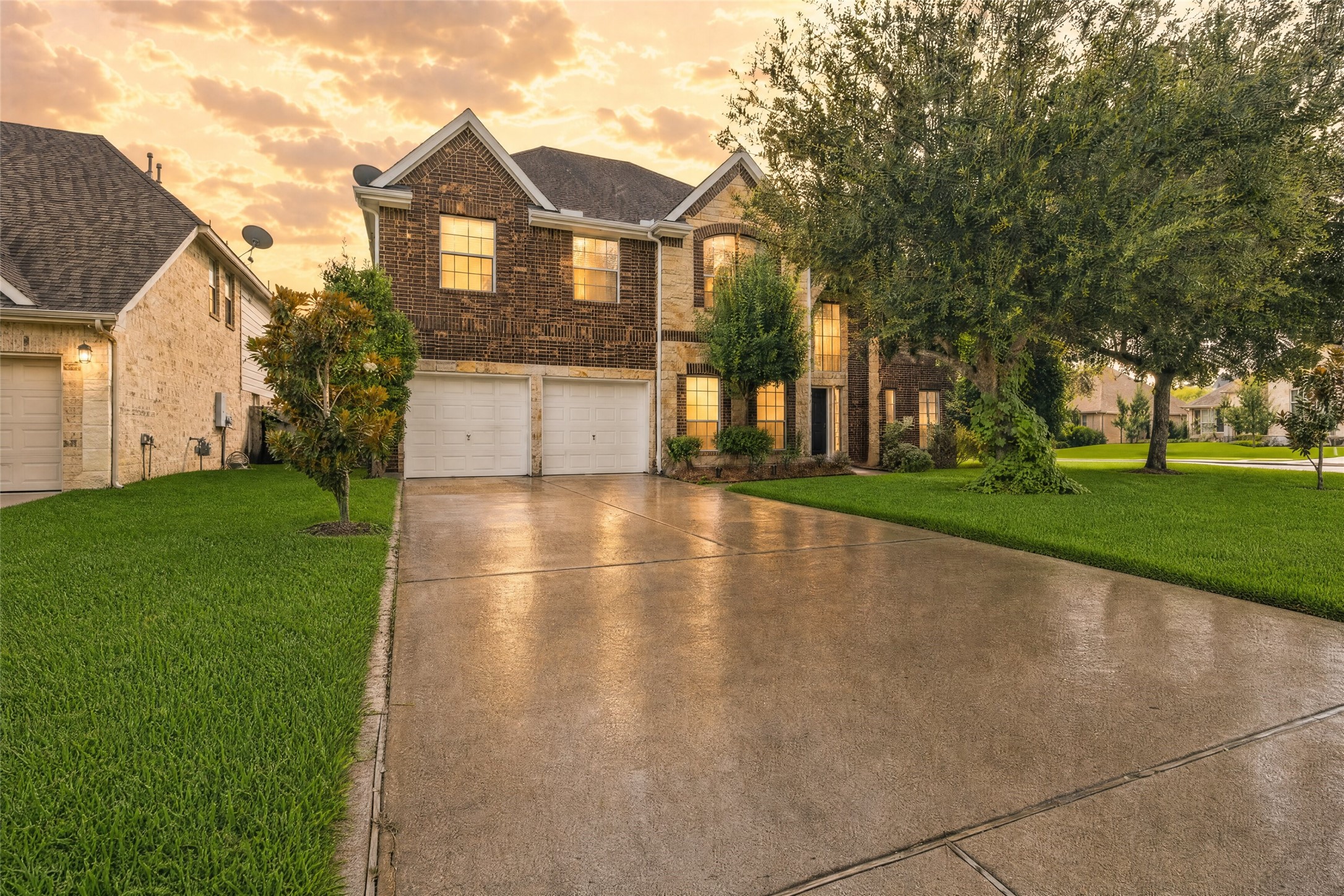 Coming home feels inviting with mature shade trees, a wide driveway, and timeless brick-and-stone curb appeal.