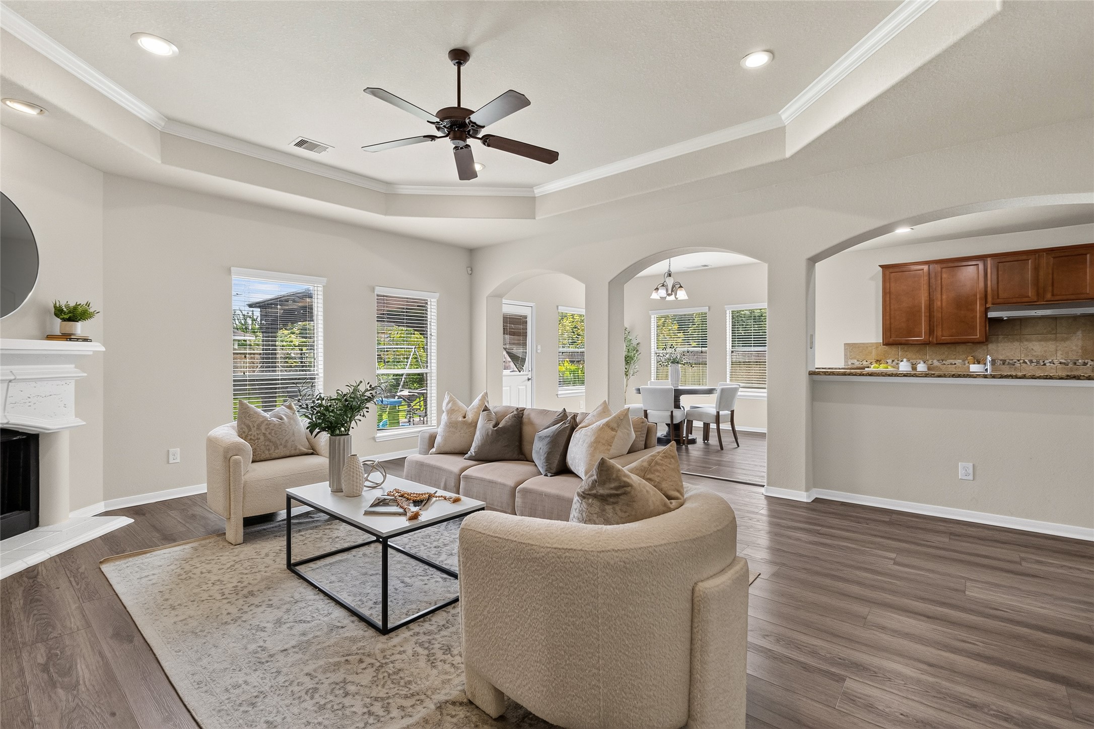 Step into your inviting living room, where soaring tray ceilings, abundant natural light, and an open layout create the perfect space to relax, entertain, and stay connected to the heart of your home.