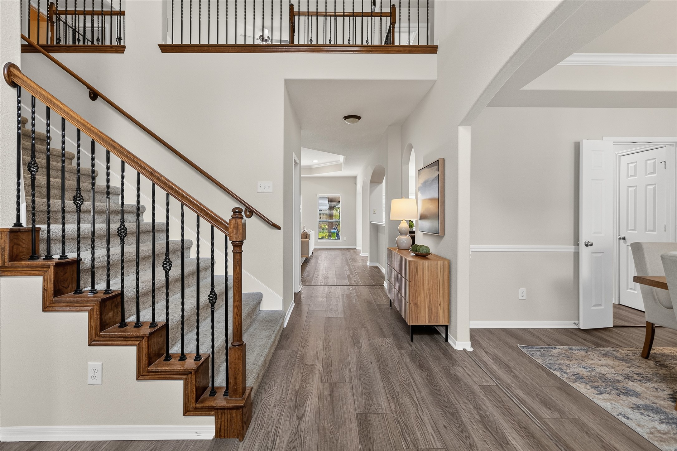 A grand two-story entry with soaring ceilings, elegant wrought-iron staircase, and rich flooring creates an impressive welcome every time you walk through the front door.
