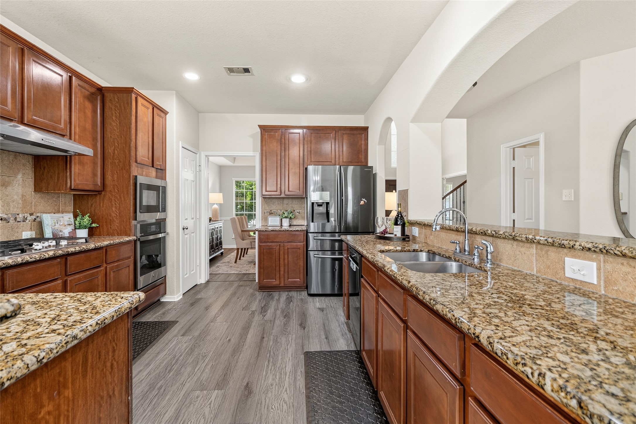 Your chef-inspired kitchen features granite countertops, abundant cabinetry, stainless steel appliances, and generous prep space for everything from weeknight meals to holiday feasts.