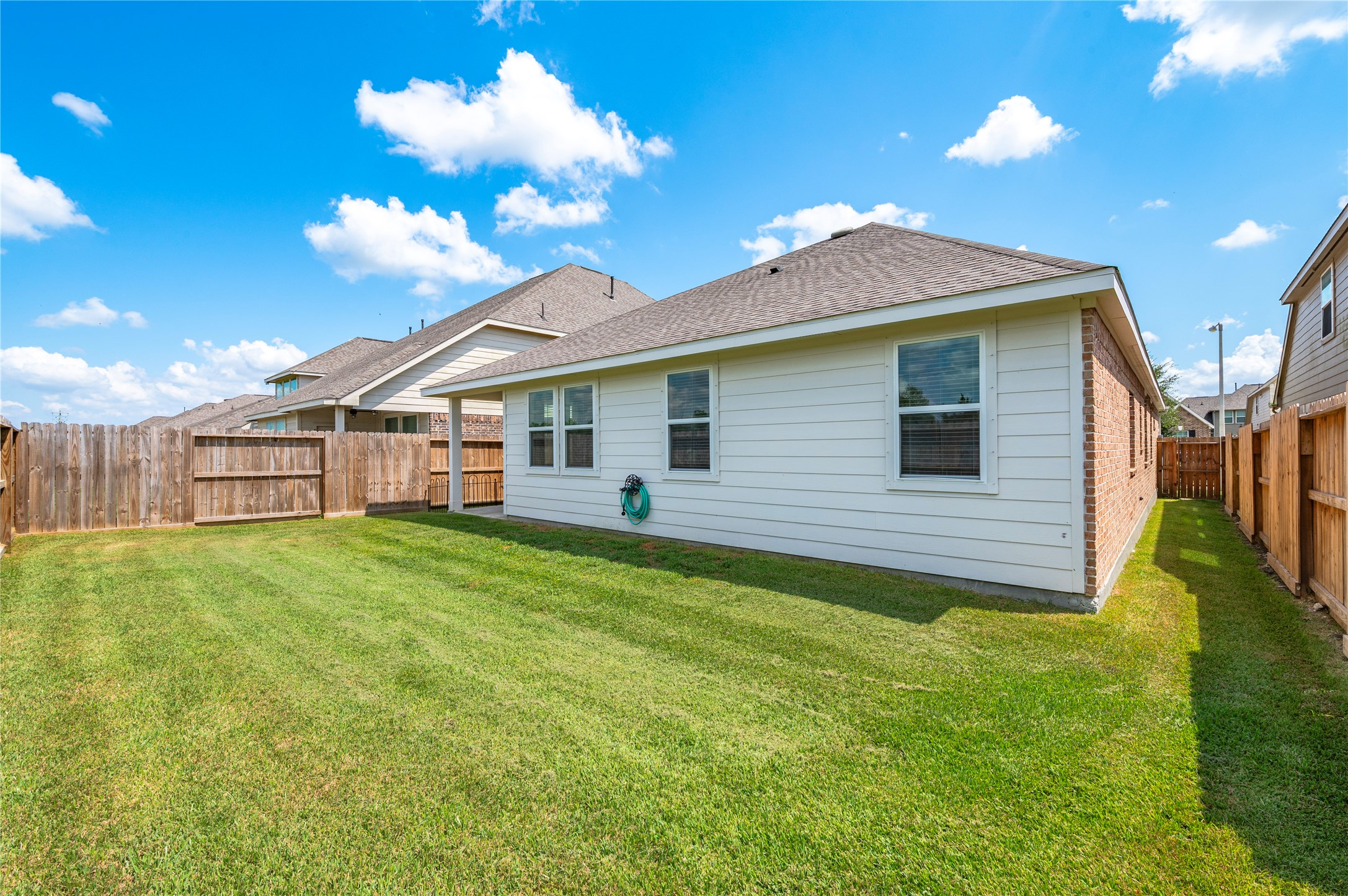 Spacious backyard with well-maintained lawn and new privacy fencing, perfect for outdoor activities and entertaining.