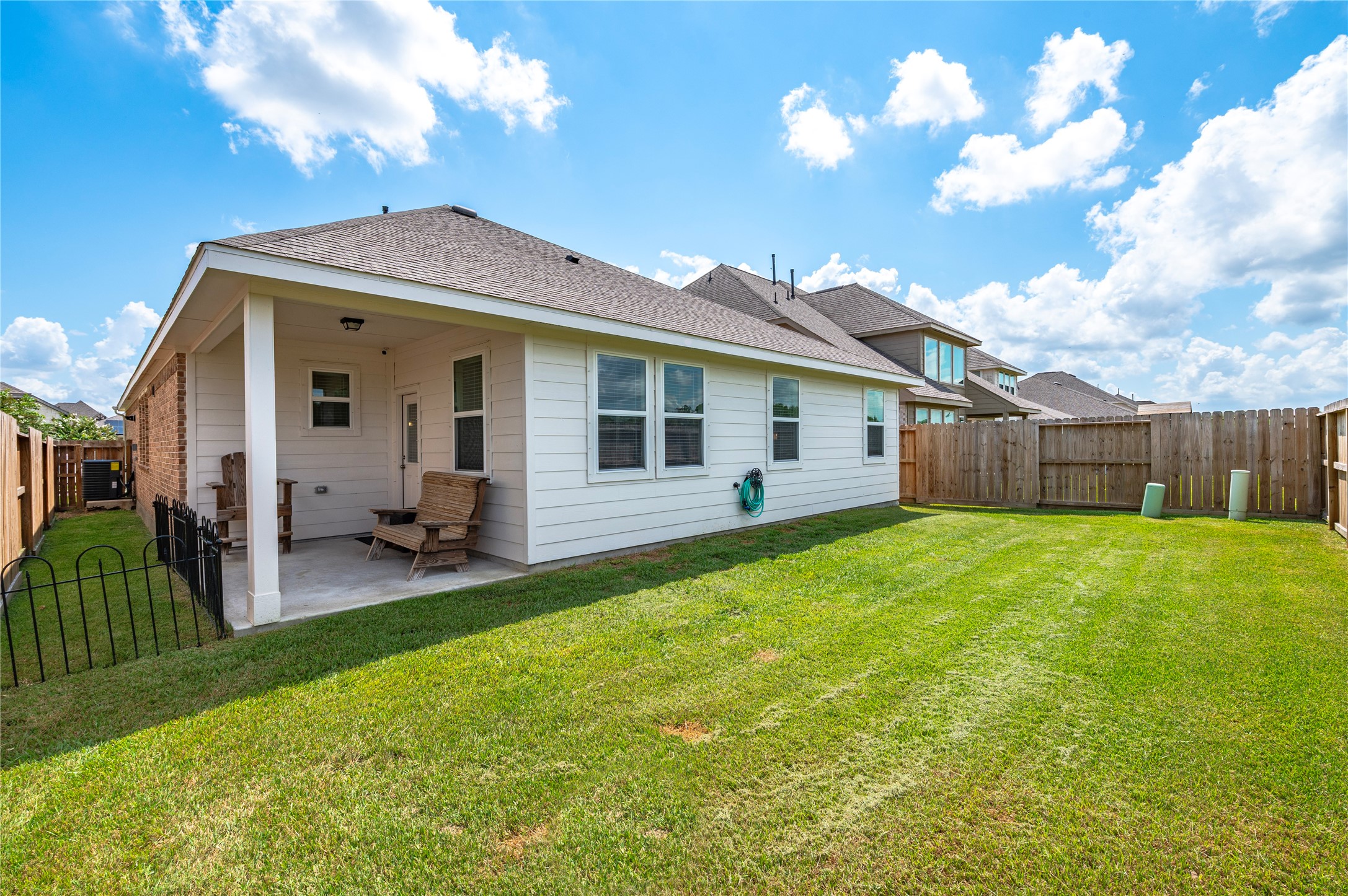 The private backyard with a well-maintained lawn and a cozy covered patio, perfect for outdoor relaxation and entertaining. The private backyard with a well-maintained lawn and a cozy covered patio, perfect for outdoor relaxation and entertaining.