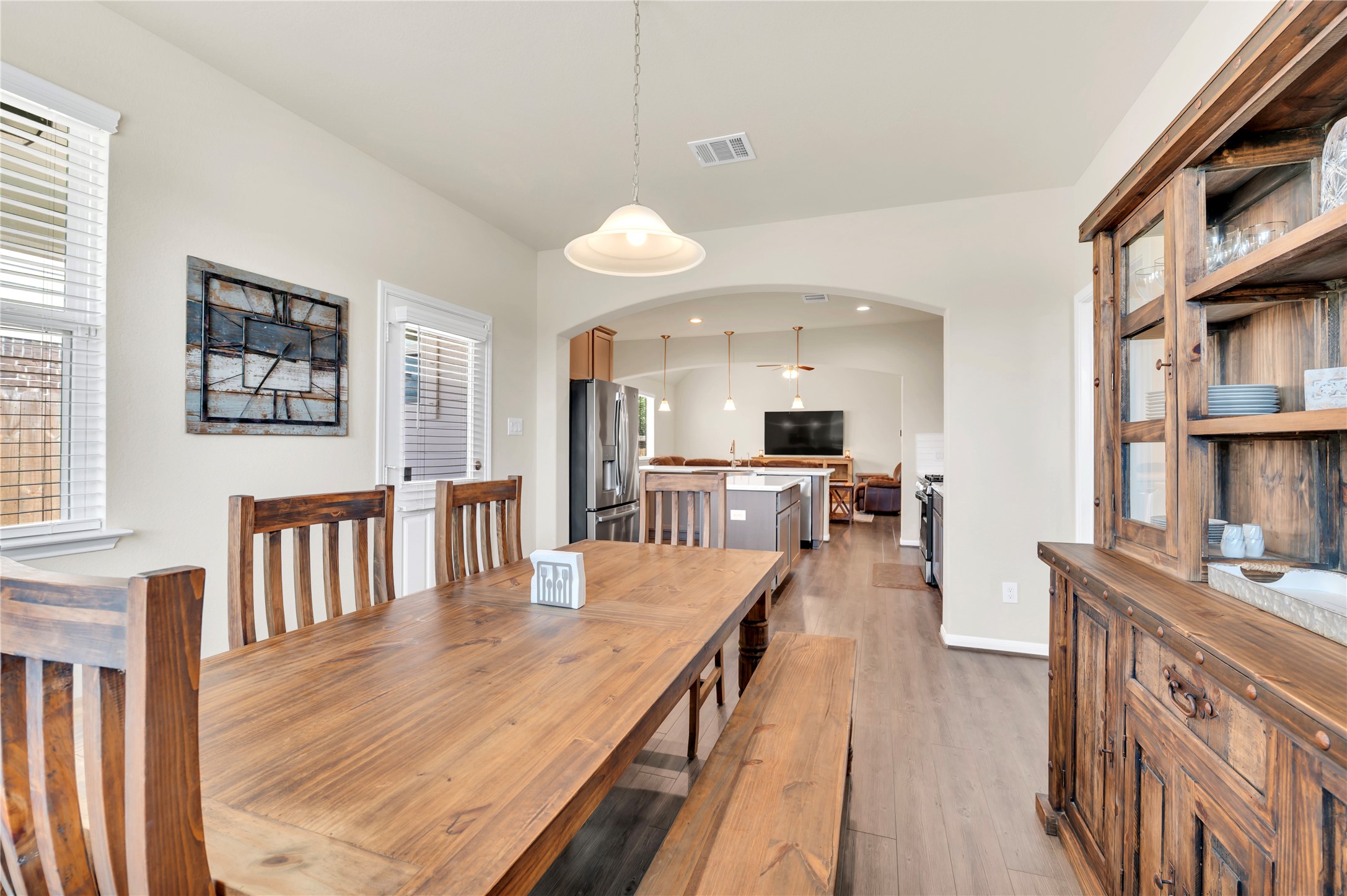 Spacious dining area with elegant wood furniture leads seamlessly into a modern kitchen and cozy living space, perfect for gatherings.