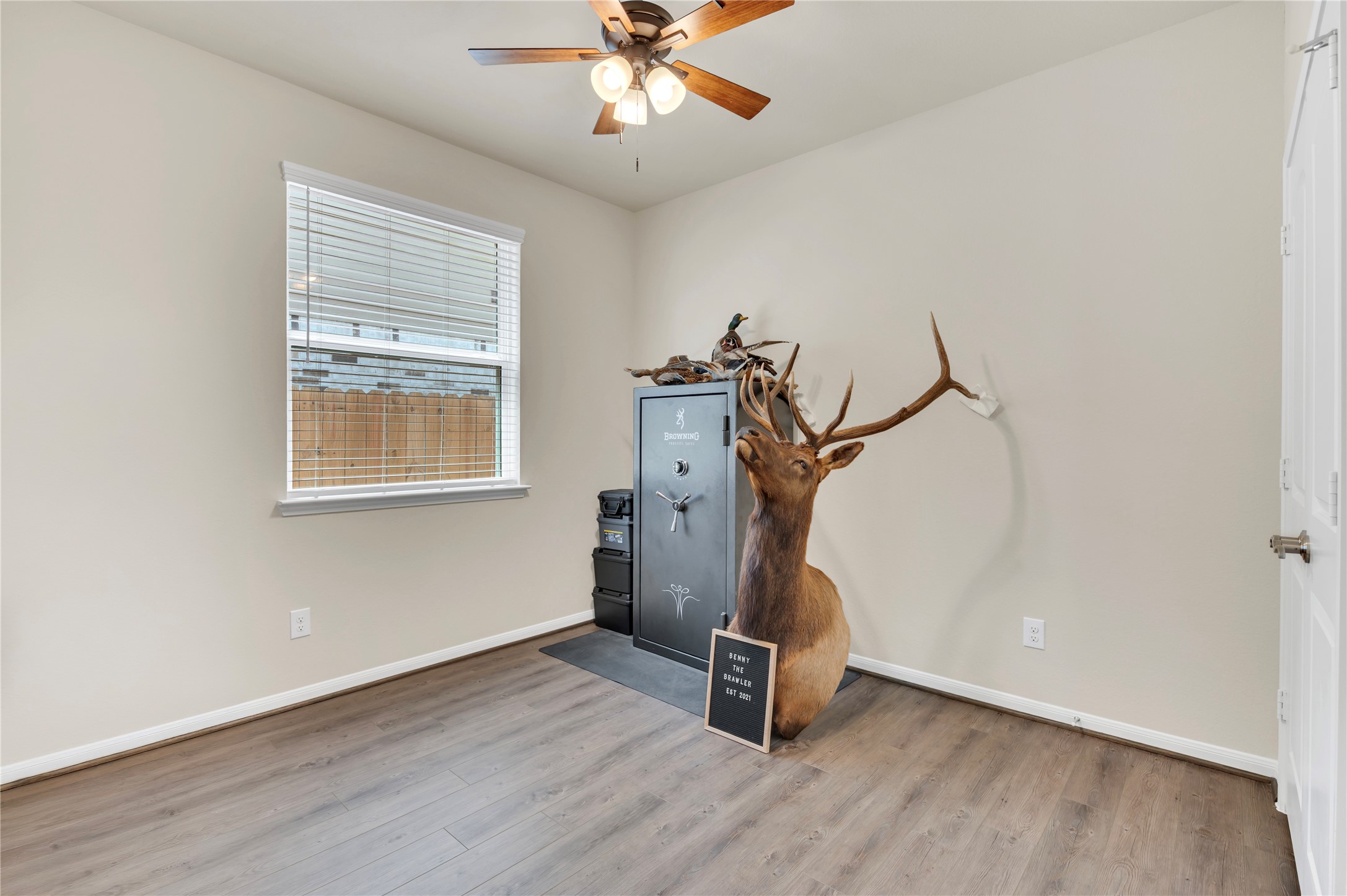 A versatile 3rd bedroom with wood flooring, neutral walls, and a ceiling fan, perfect for use as a study or hobby space.