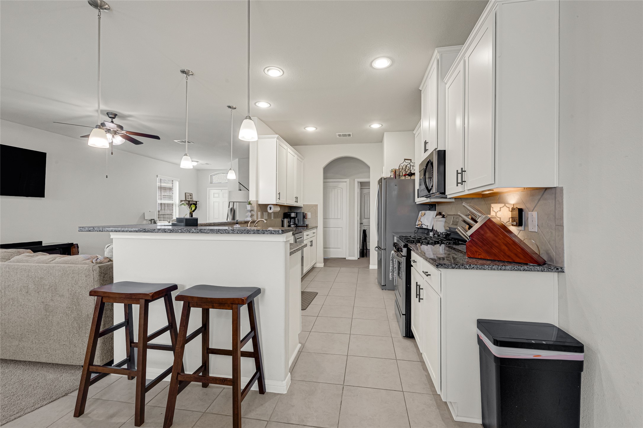 Modern kitchen with granite countertops, ample cabinetry, and breakfast bar seating. Modern kitchen with granite countertops, ample cabinetry, and breakfast bar seating.