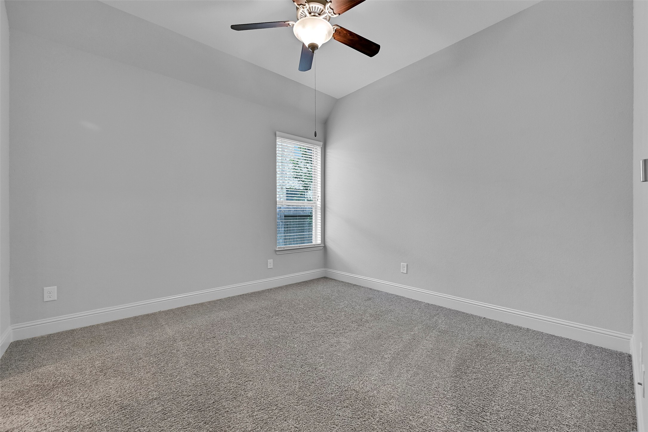 This spacious secondary bedroom features plush carpet, a ceiling fan, large window with backyard views, and a neutral color palette ready for any dcor style. Conveniently located on the first floor, it offers comfort and privacy for family members or overnight guests.