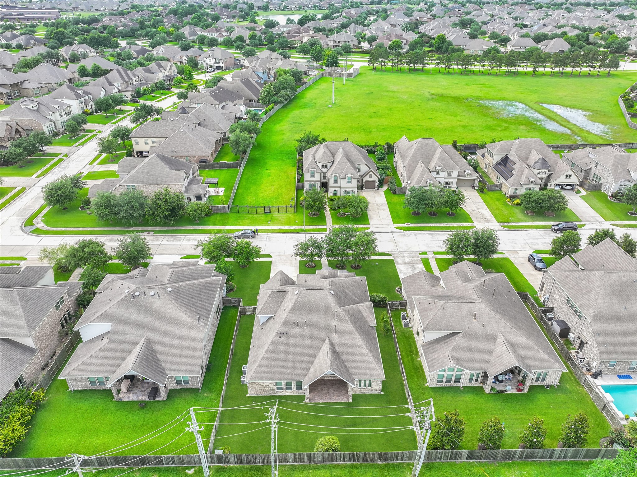 An aerial perspective highlights the home's generous lot size and desirable position within West Ranch. The backyard offers exceptional outdoor space compared to many newer homes, while the surrounding neighborhood showcases the community's attractive streetscapes, mature landscaping, and well-maintained homes.