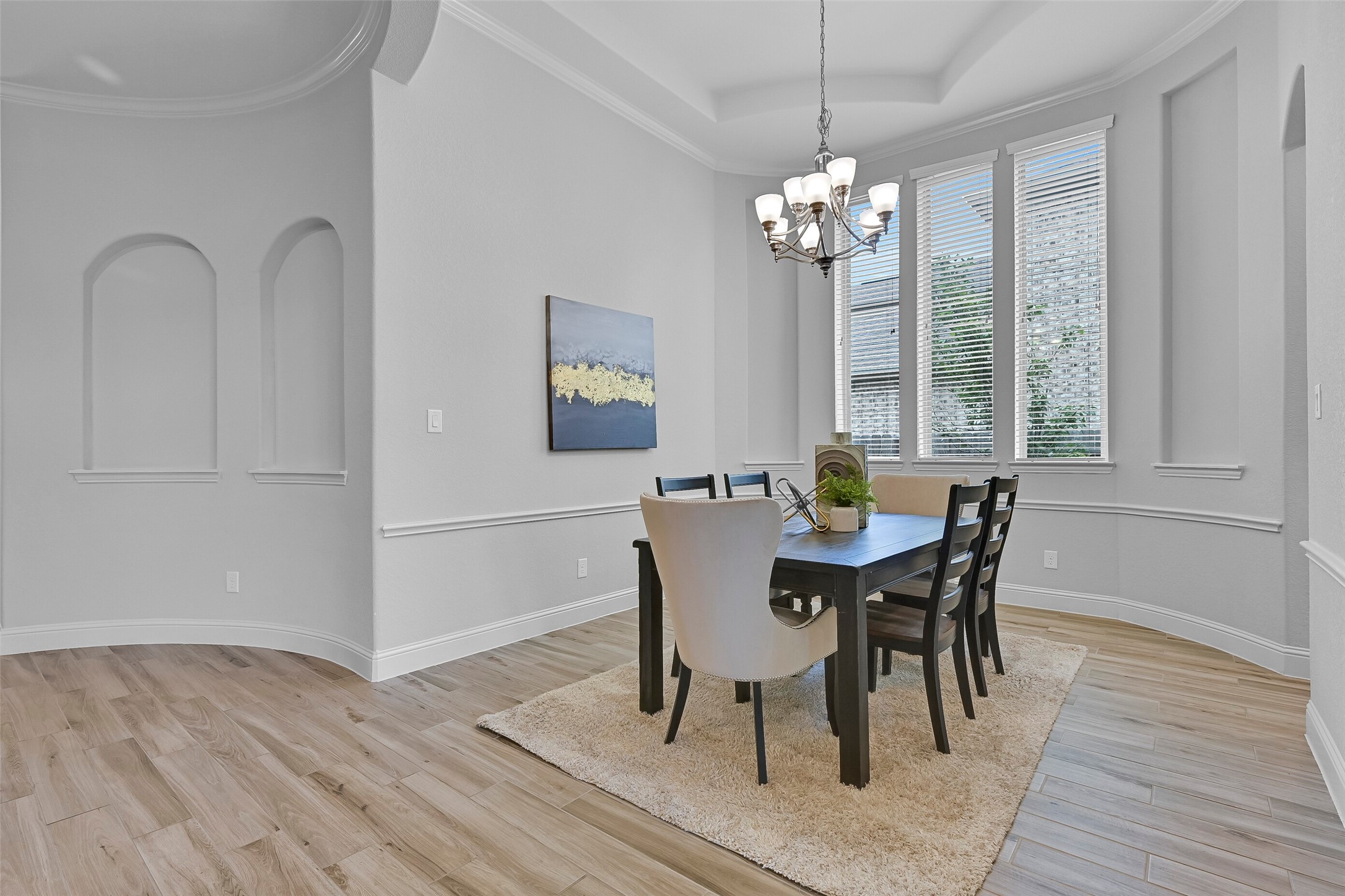An alternate view highlights the generous proportions of the dining room and its central location within the home. Architectural arches, detailed trim work, and the open flow between the foyer, kitchen, and family room create a welcoming layout for both everyday living and special occasions.