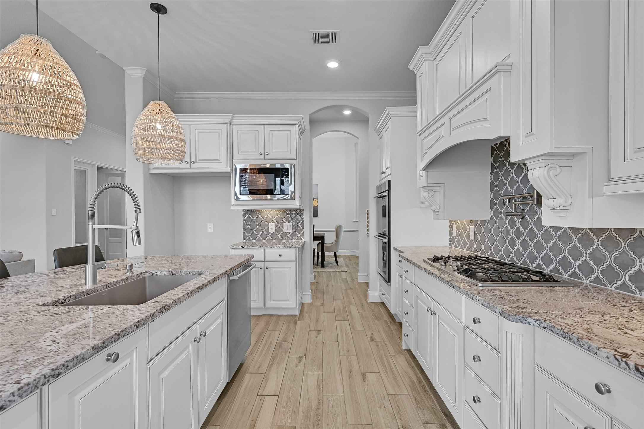 Designed with the home chef in mind, this kitchen offers extensive counter space, a 5-burner Electrolux gas cooktop with pot filler, undercabinet lighting, and abundant storage. The thoughtful layout keeps everything within easy reach while maintaining an open connection to the living areas.