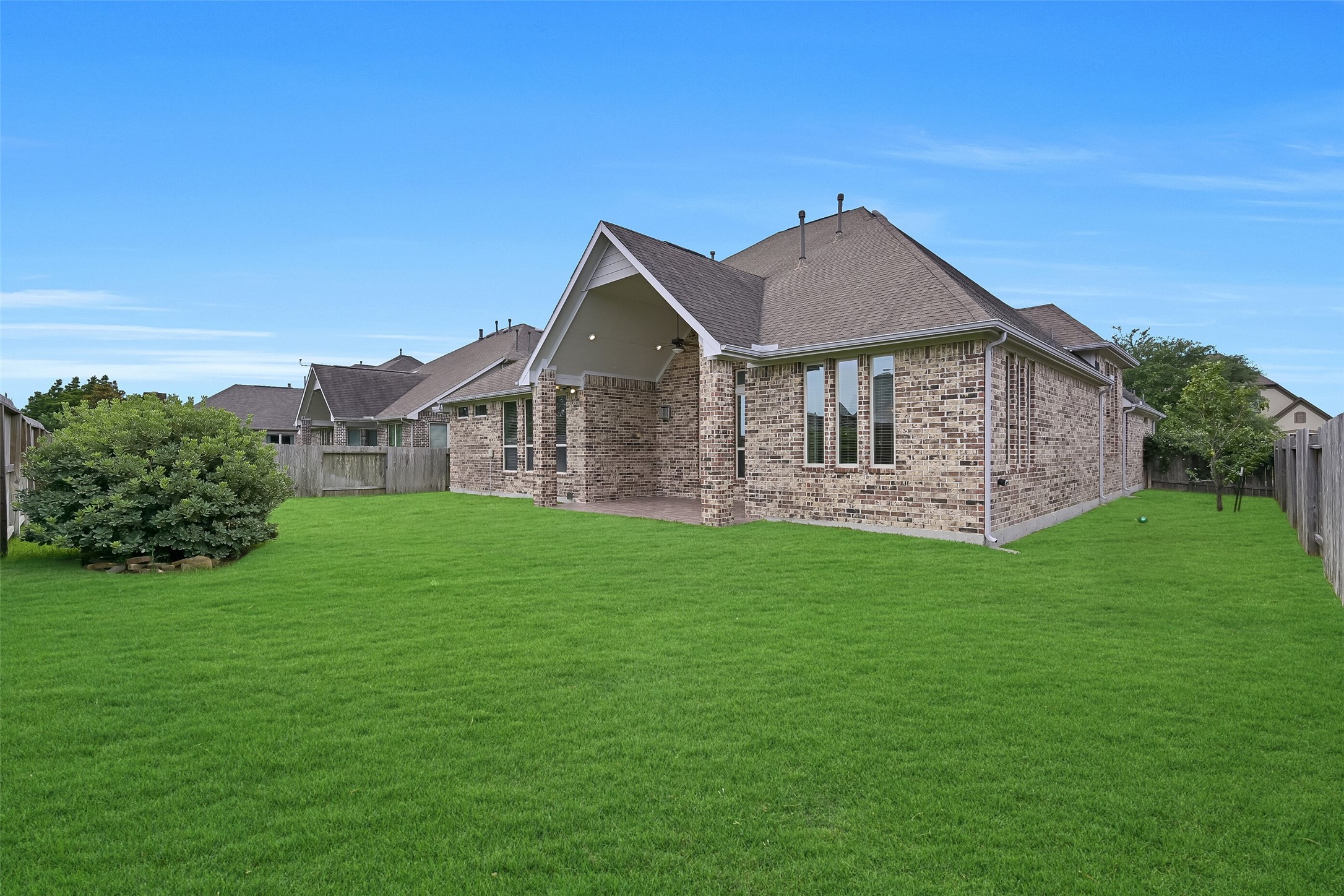 The oversized backyard offers endless possibilities, whether you envision a future pool, play space, garden, or outdoor entertaining area. The extended rear elevation showcases the home's thoughtful design, while the covered patio creates a seamless connection between indoor and outdoor living. With no immediate rear neighbors and abundant green space, the setting feels both open and private.
