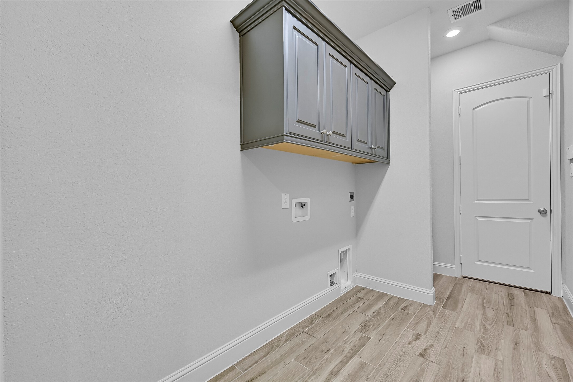 Conveniently located just off the garage, the spacious utility room combines functionality and storage with upper cabinetry, washer/dryer connections, and durable tile flooring. A built-in mudroom drop zone provides the perfect place for daily essentials, while the additional wall space easily accommodates a second refrigerator or freezer for extra household storage.
