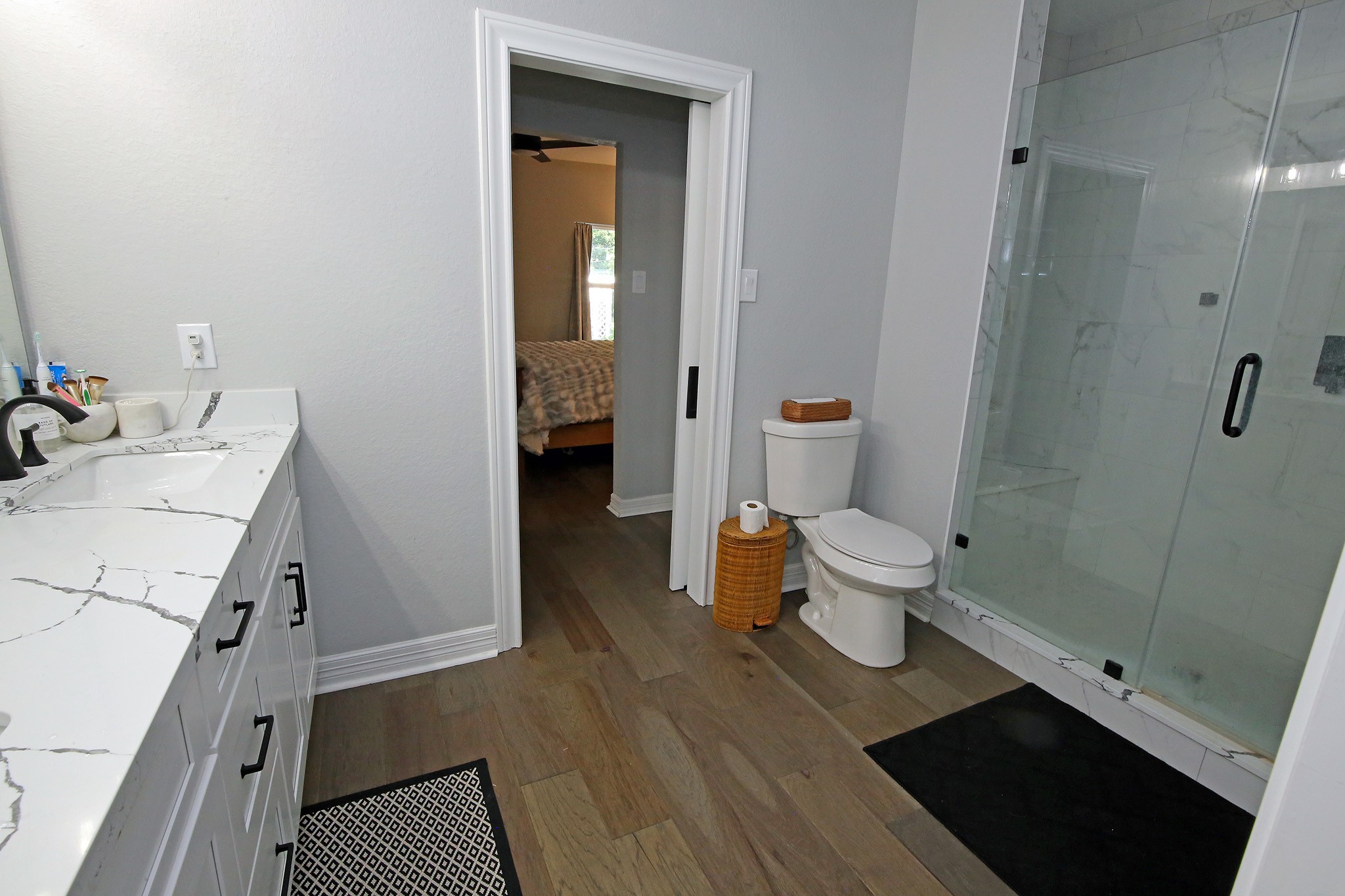 Bathroom with oversized shower and wood flooring and quartz countertops