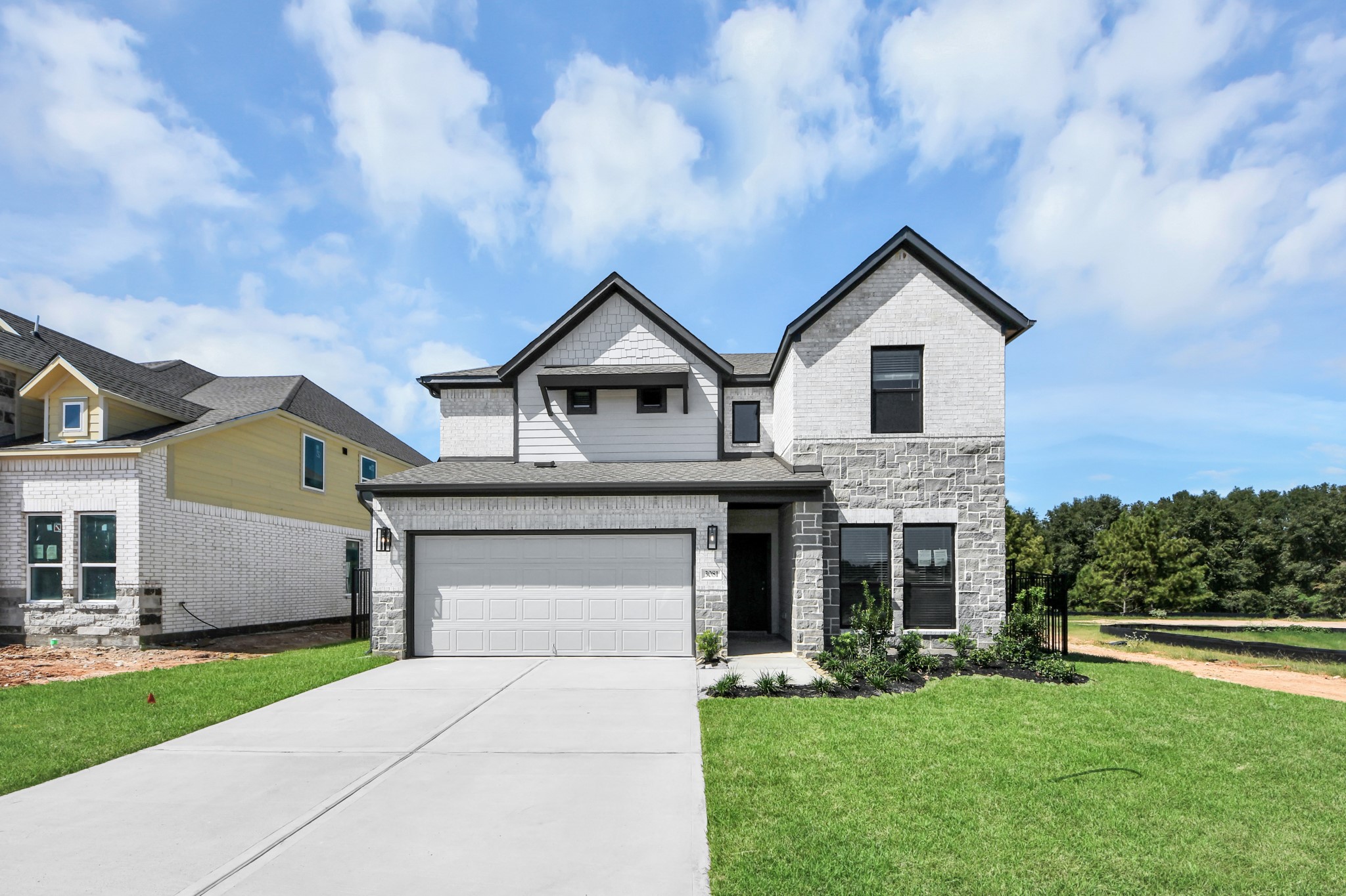 This home boasts lush green grass and meticulous landscaping. Its premium elevation showcases an exquisite blend of brick and stone features, complemented by modern coach lighting This home boasts lush green grass and meticulous landscaping. Its premium elevation showcases an exquisite blend of brick and stone features, complemented by modern coach lighting
