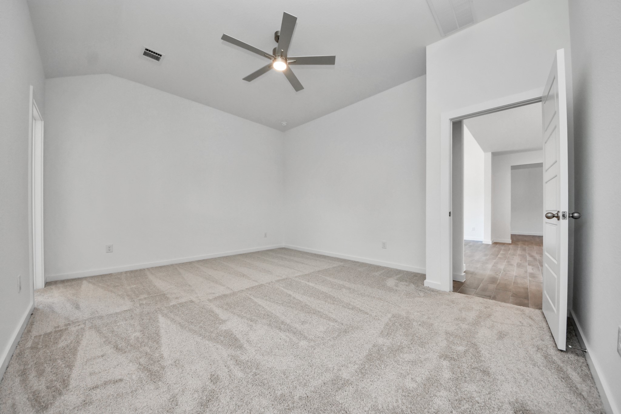 Escape and relax in the exquisite primary suite, a haven to unwind after a long day. The spacious room, located on first floor, boasts plush carpeting, soothing paint tones, high ceilings, and expansive windows adorned with privacy blinds.