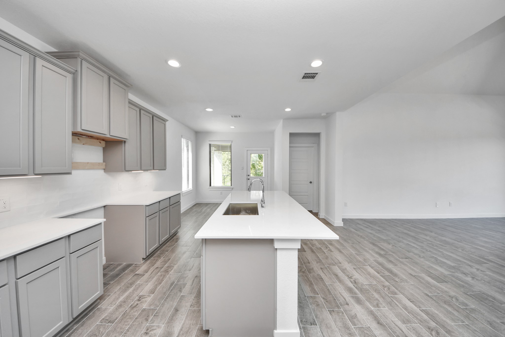 This generously spacious kitchen is a dream realized! With a massive granite island, high ceilings, soft close cabinets, granite countertops, stainless steel appliances, a sleek tile backsplash, recessed lighting, and an extended counter area, it offers both style and practicality. All this opens up to the expansive family room, creating a perfect hub for gatherings.