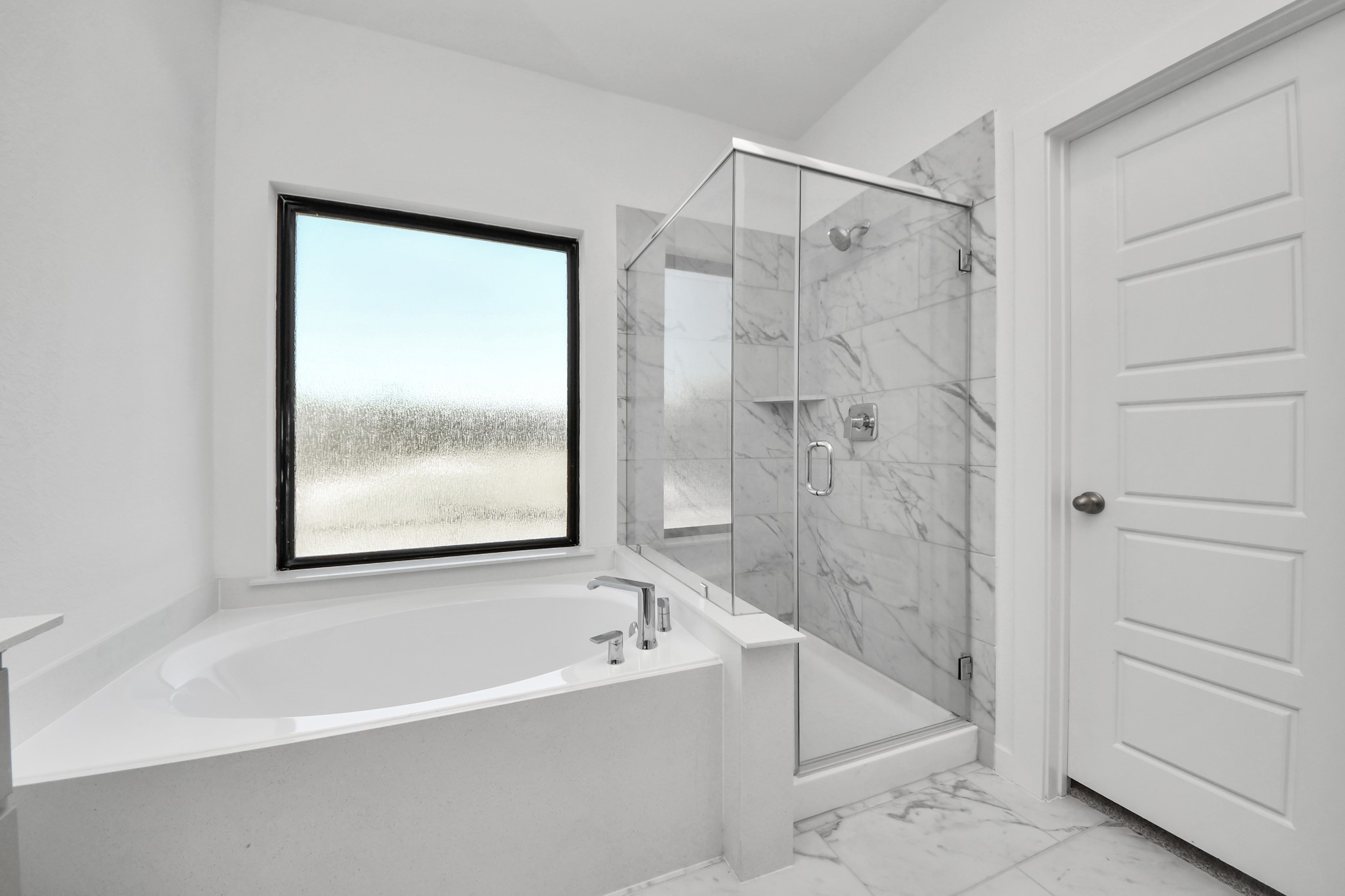Indulge in a spa-like retreat within the confines of this primary bathroom. Delight in a spacious walk-in shower enveloped in stylish tile surround, unwind in a separate garden tub adorned with custom detailing.