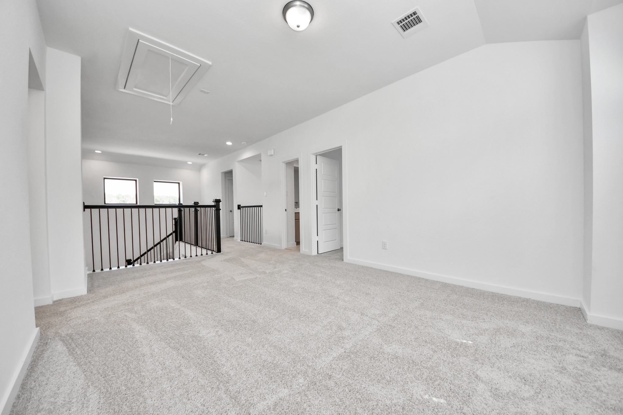 Discover a haven of leisure in this fantastic game room! Whether you're seeking a casual hangout or an adult gaming retreat, this space has it all. Enjoy the luxurious feel of plush carpet underfoot, the expansive ambiance of high ceilings, custom paint that adds a touch of personality, and windows that flood the room with refreshing natural light.
