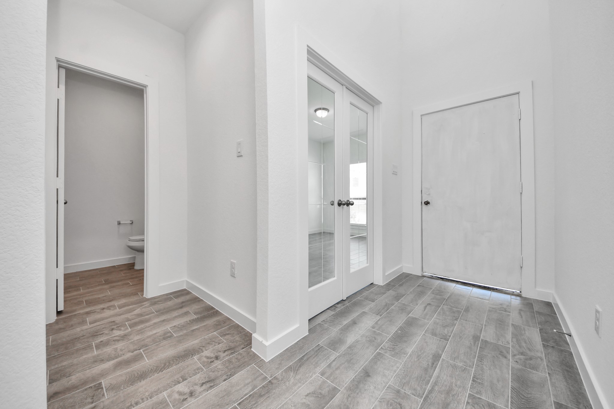 As you step into the threshold of this luxurious home, you'll soon be welcomed by an elegant glass door (to be installed). Inside, soaring ceilings amplify the spaciousness, while the refined wood-look tile flooring and oversized baseboards exude sophistication and charm.
