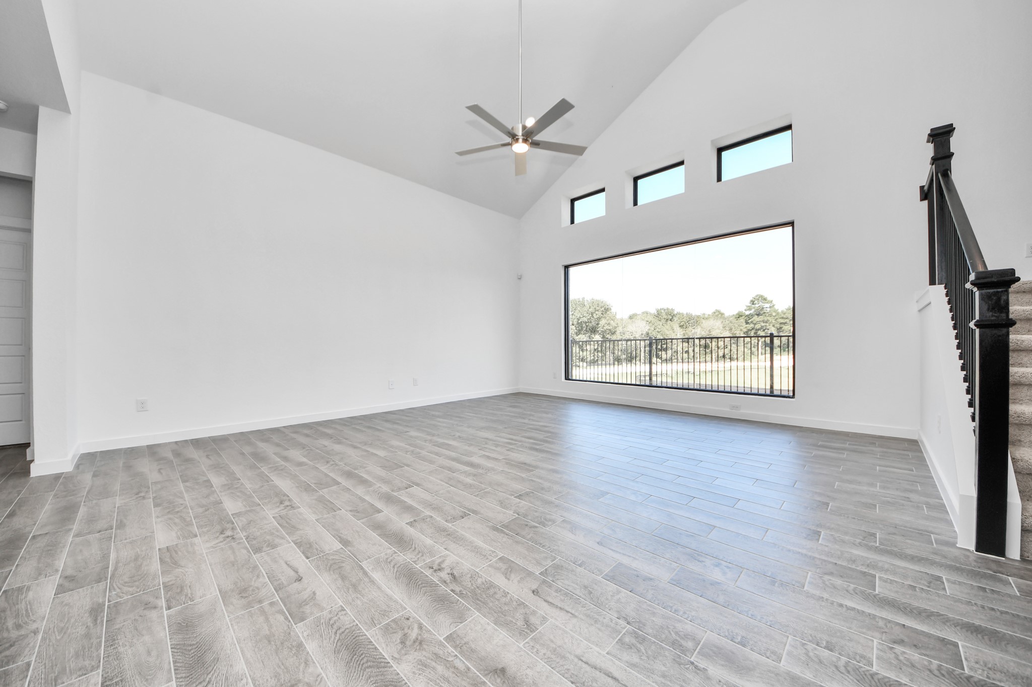 Welcome family and guests to your charming living room! With its high ceilings, recessed lighting, ceiling fan, custom paint, beautiful flooring, and large windows that let in abundant natural light, this room is perfect for gatherings.
