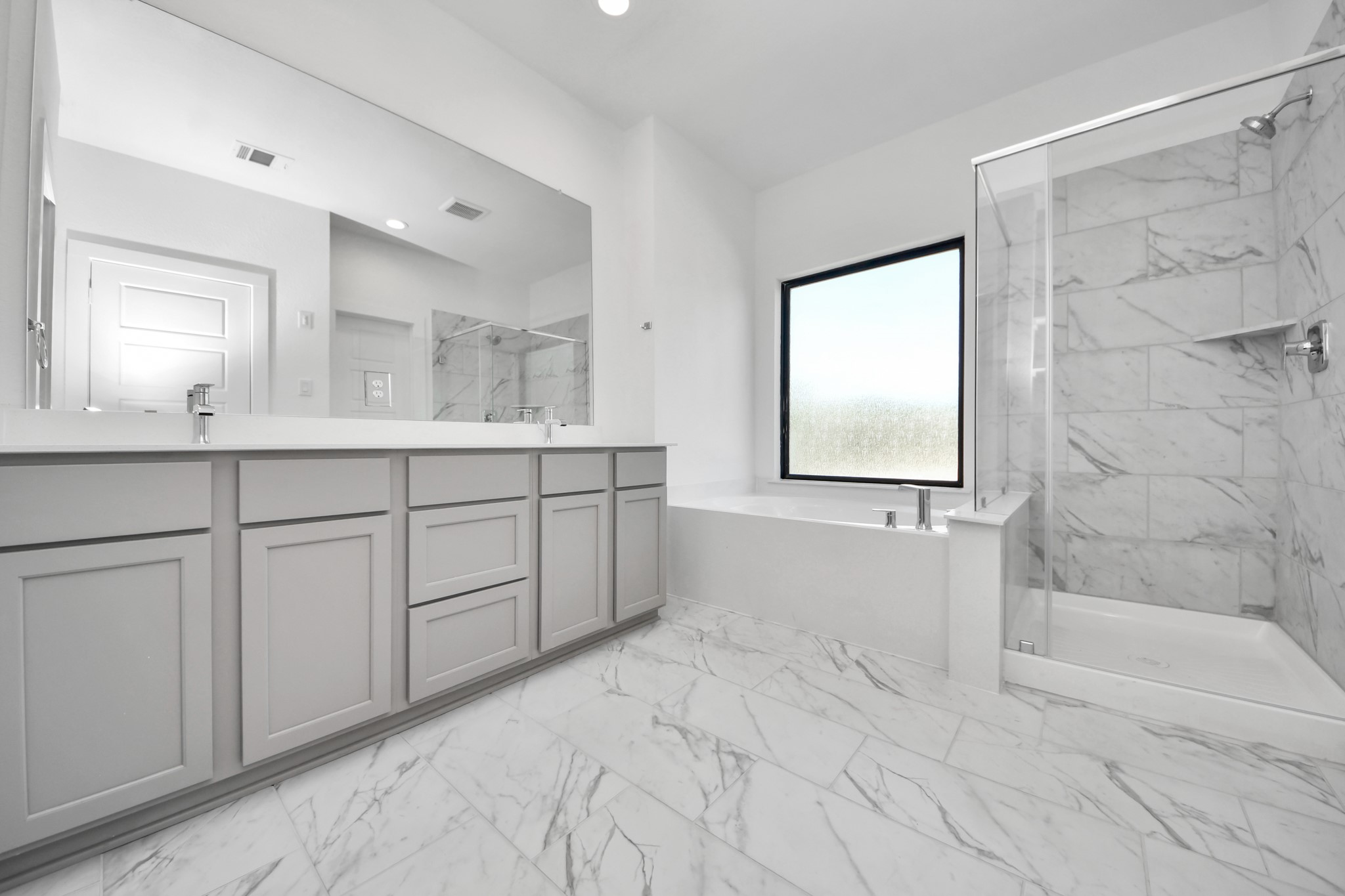 Escape to a spa-like oasis in this primary bathroom. Enjoy a walk-in shower with tile surround, a separate garden tub with custom detailing, and an elegant vanity featuring light countertops, modern hardware, and beautiful vanity lights. Experience luxury and relaxation in every detail.