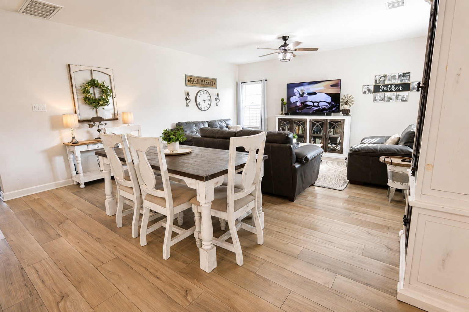 Charming open-concept living and dining area features elegant laminate flooring.