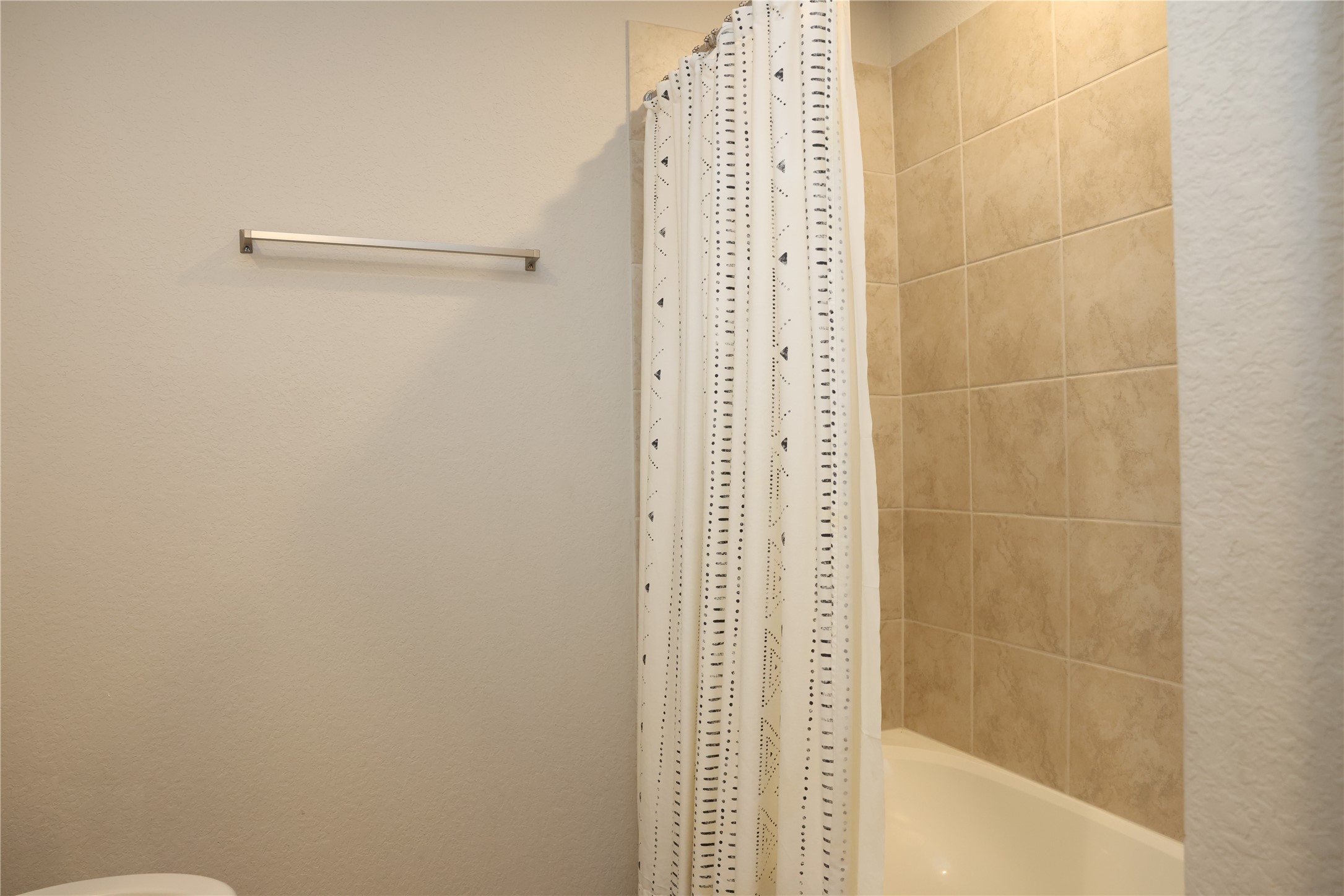 A stylish secondary bathroom featuring elegant tiled walls and a modern shower, ideal for guests or family.