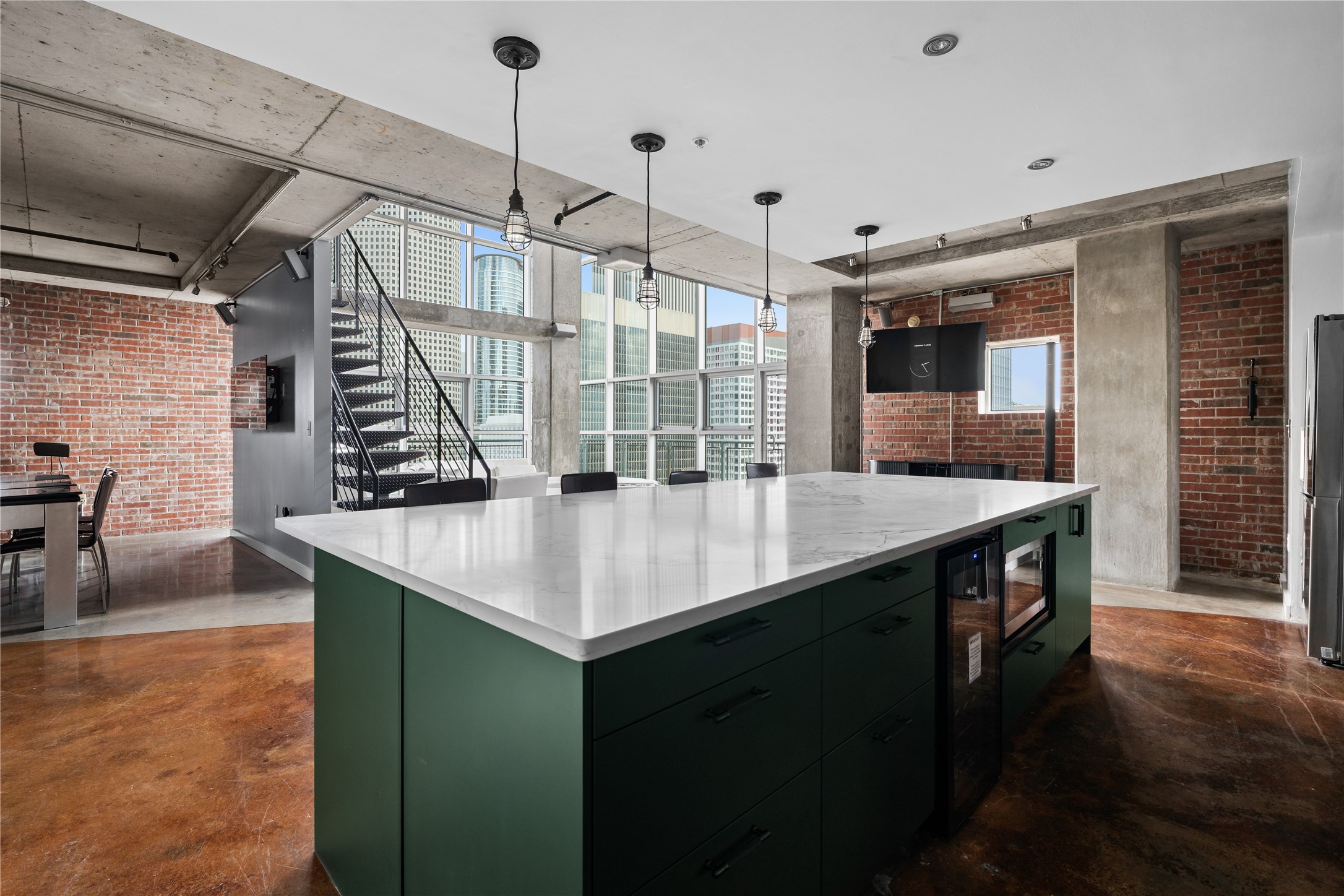 The oversized island anchors the kitchen while maintaining an open connection to the lofts dramatic two story living space and signature industrial architecture.