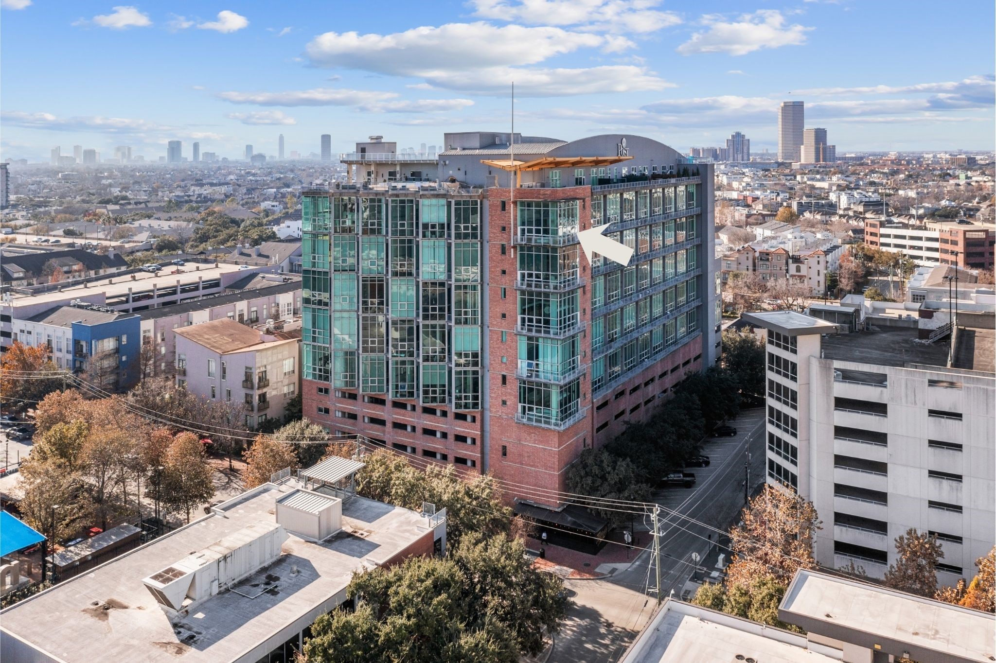 Aerial view of Rise Lofts, showcasing its distinctive architecture and prominent setting in the heart of Midtown, surrounded by Houstons urban landscape.The only active condo in the development with a penthouse feel.