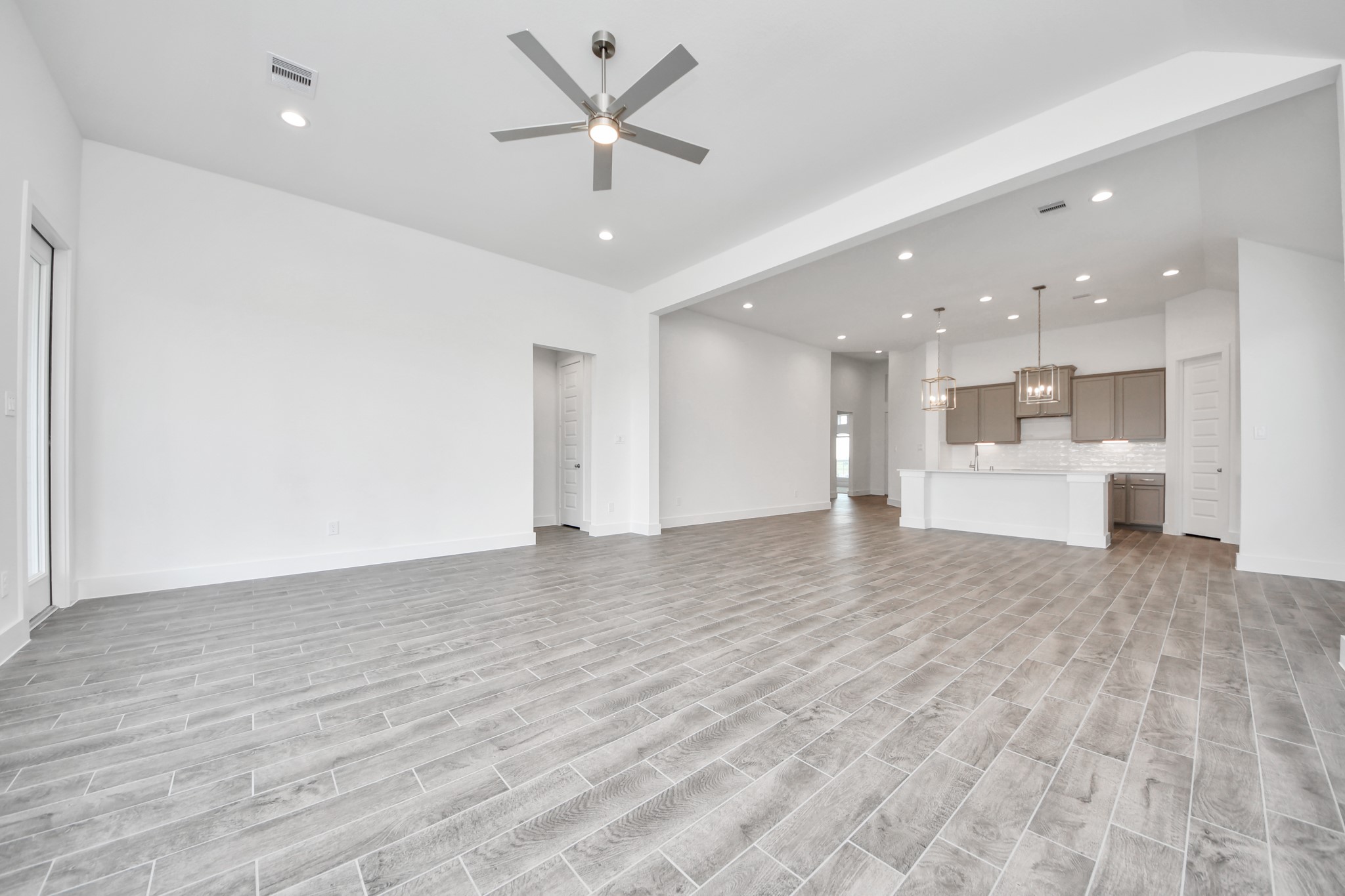 Gather the family and guests together in your lovely living room! Featuring soaring high ceilings, recessed lighting, ceiling fan, custom paint, gorgeous floors, and large windows that provide plenty of natural lighting throughout the day. Sample photo of completed home with similar floor plan. Actual colors and selections may vary.