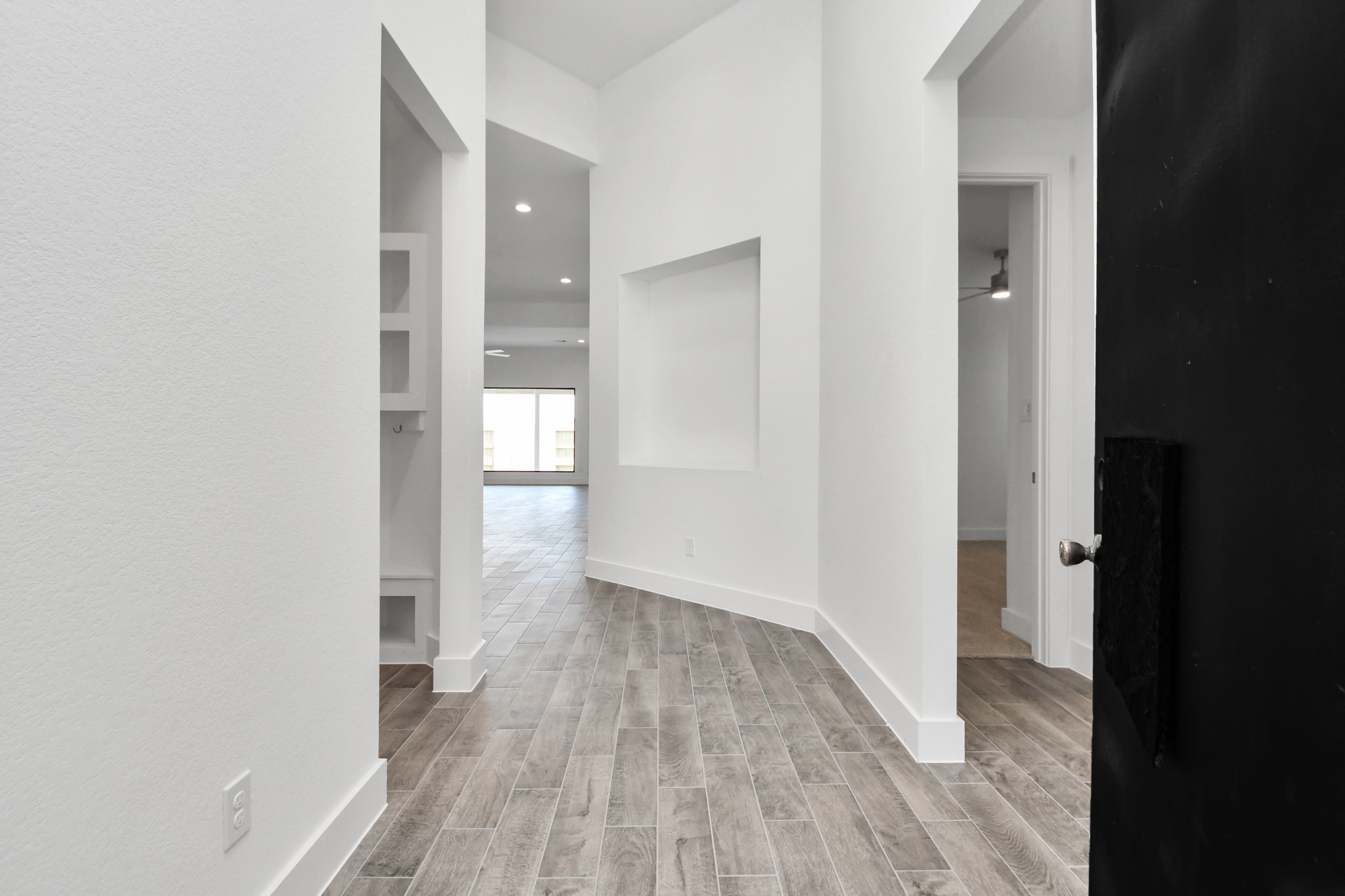 As you step into the threshold of this luxurious home, you'll soon be welcomed by an elegant glass door (to be installed). Inside, soaring ceilings amplify the spaciousness, while the refined wood-look tile flooring and oversized baseboards exude sophistication and charm. Sample photo of completed home with similar floor plan. Actual colors and selections may vary. As you step into the threshold of this luxurious home, you'll soon be welcomed by an elegant glass door (to be installed). Inside, soaring ceilings amplify the spaciousness, while the refined wood-look tile flooring and oversized baseboards exude sophistication and charm. Sample photo of completed home with similar floor plan. Actual colors and selections may vary.