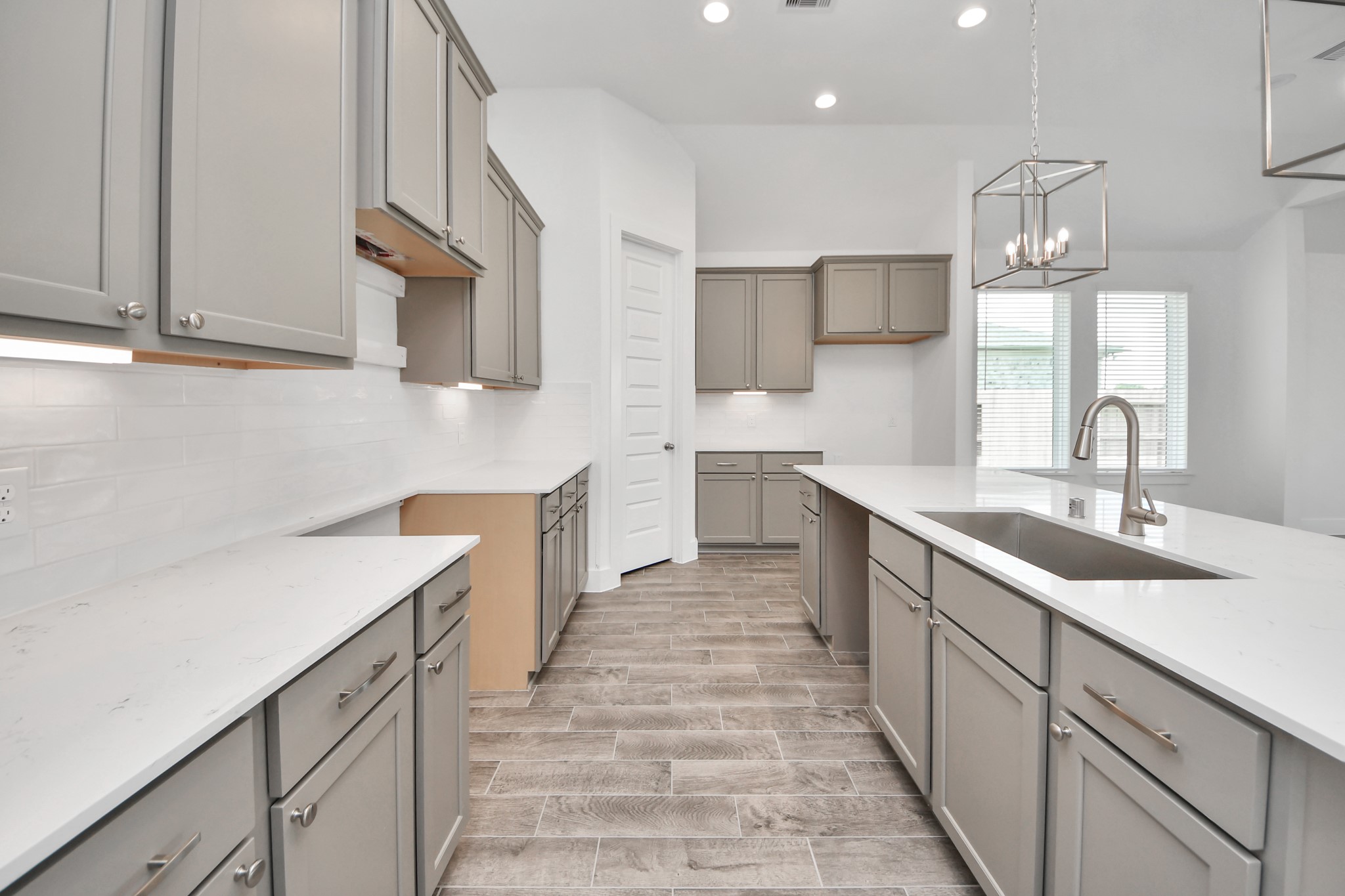 The kitchen is a culinary haven, featuring granite countertops, a tile backsplash, stainless steel appliances, 42 upper cabinets, and undercabinet lighting. Sample photo of completed home with similar floor plan. Actual colors and selections may vary. The kitchen is a culinary haven, featuring granite countertops, a tile backsplash, stainless steel appliances, 42 upper cabinets, and undercabinet lighting. Sample photo of completed home with similar floor plan. Actual colors and selections may vary.