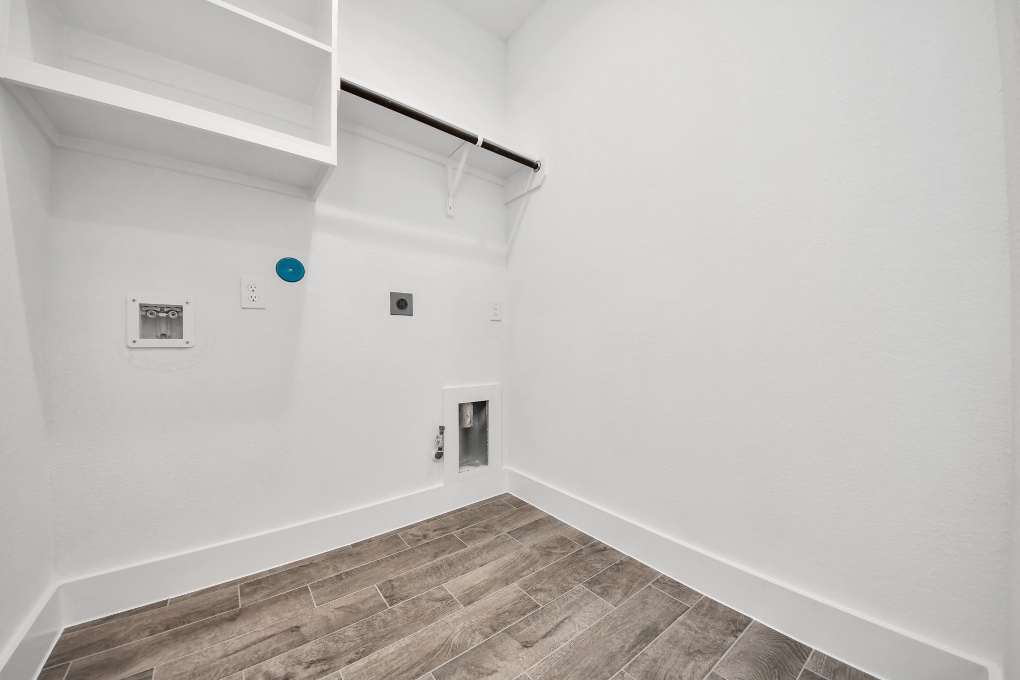A perfect blend of functionality and comfort. Capture the essence of easy living with a first-floor laundry room, thoughtfully equipped with shelving for effortless organization. Both electric and gas connections available. Sample photo of completed home with similar floor plan. Actual colors and selections may vary.