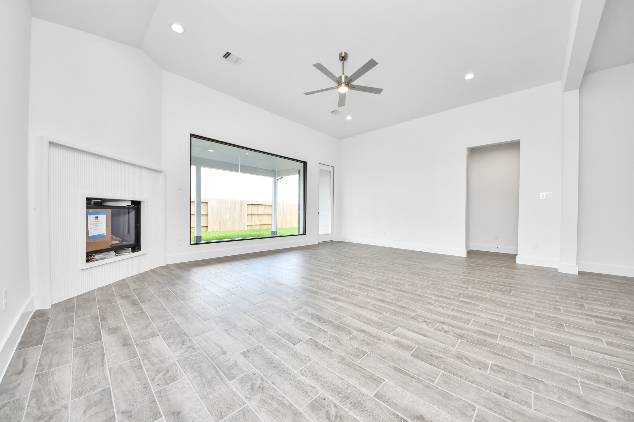 Welcome family and guests to your charming living room! With its high ceilings, recessed lighting, ceiling fan, custom paint, beautiful flooring, and large windows that let in abundant natural light, this room is perfect for gatherings. Sample photo of completed home with similar floor plan. Actual colors and selections may vary.