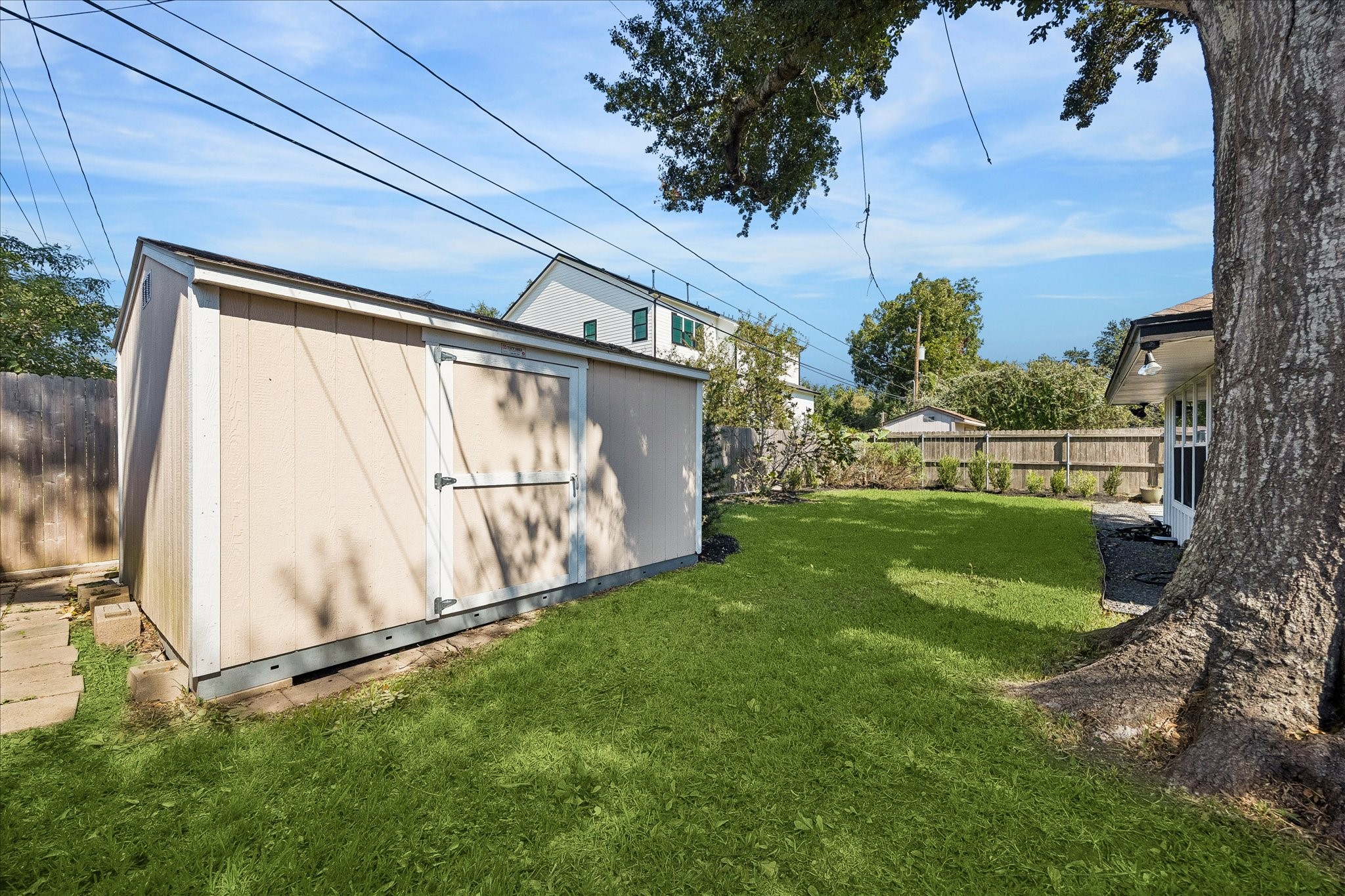 Expansive lawn, established greenery, and beautiful shade create a peaceful outdoor escape.