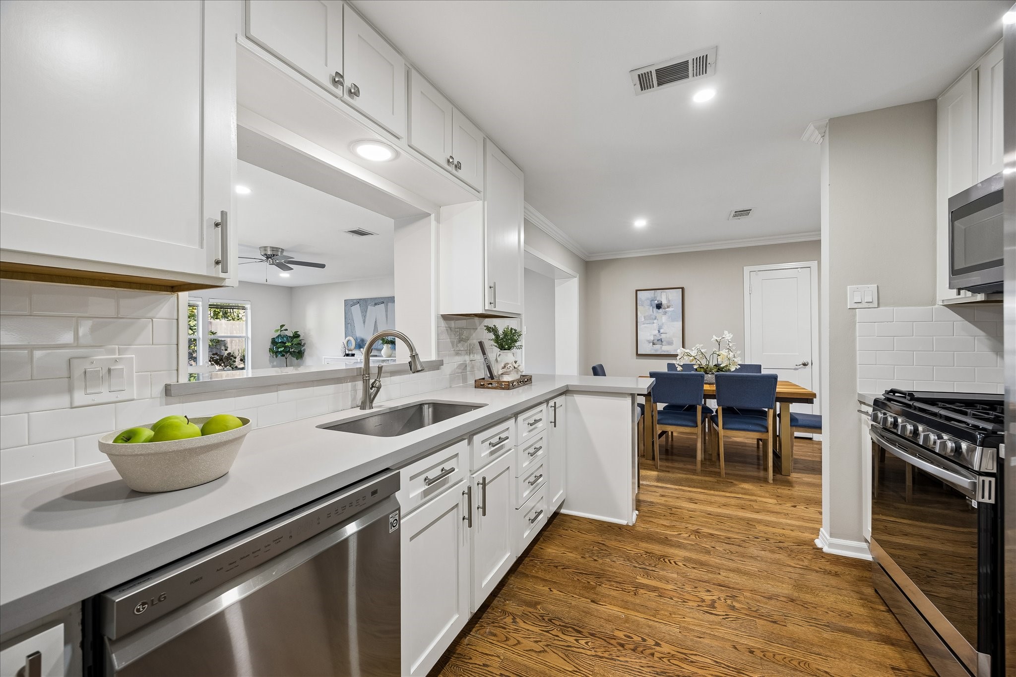 Crisp white cabinetry, stainless steel appliances, and timeless finishes create a bright culinary space.