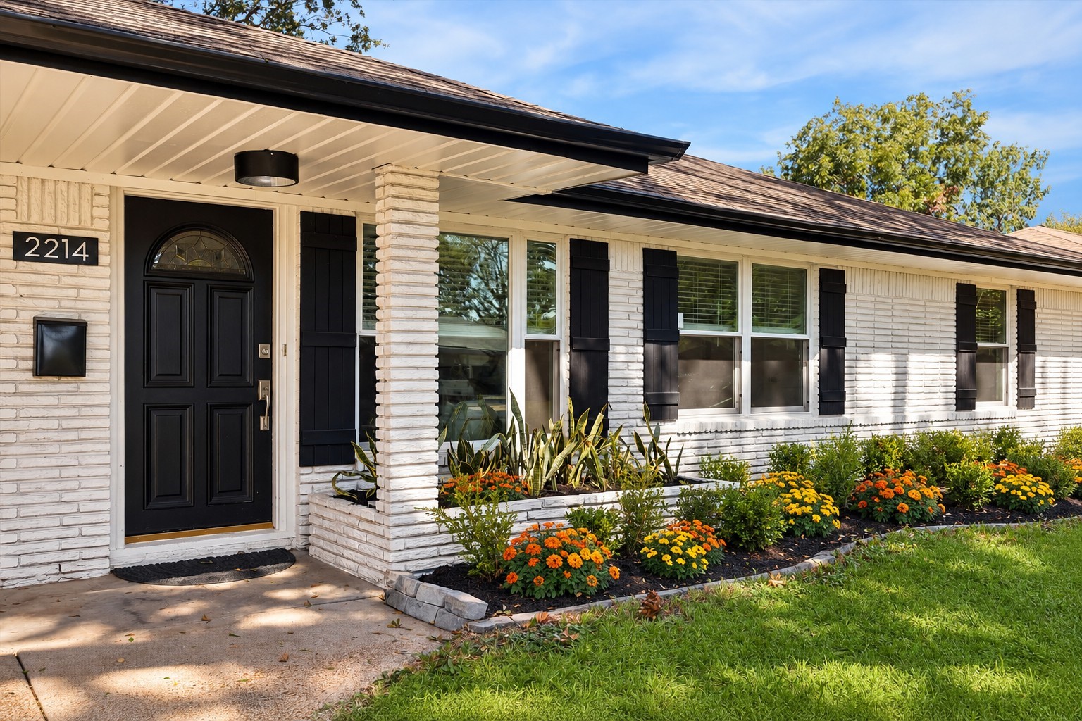 White painted brick, contrasting black accents.  This photo has been virtually staged for the flowers bed.